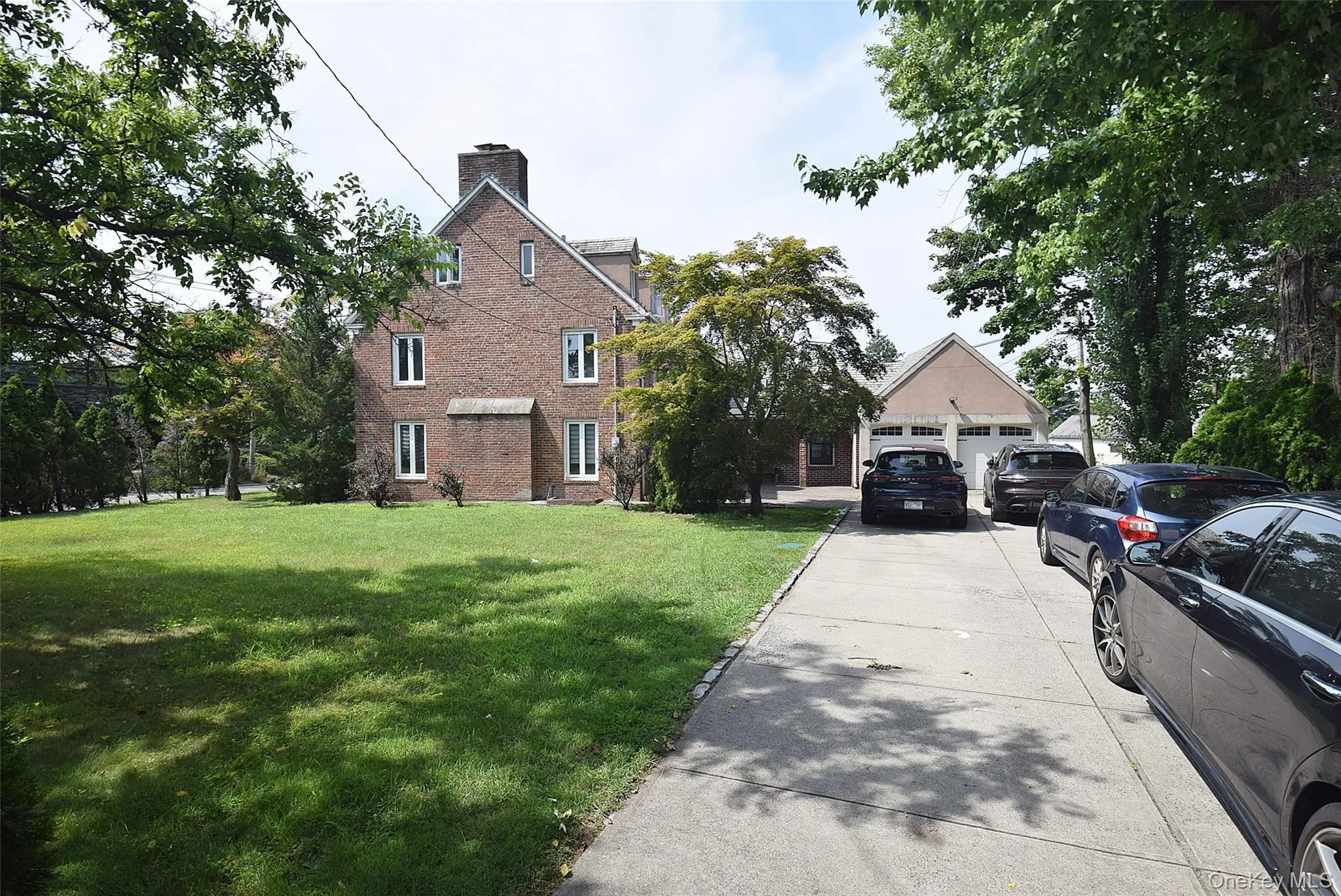 Brick exterior with multiple windows, a prominent chimney, and a two-car garage with gabled roofline. Plenty of parking. Brick exterior with multiple windows, a prominent chimney, and a two-car garage with gabled roofline. Plenty of parking.