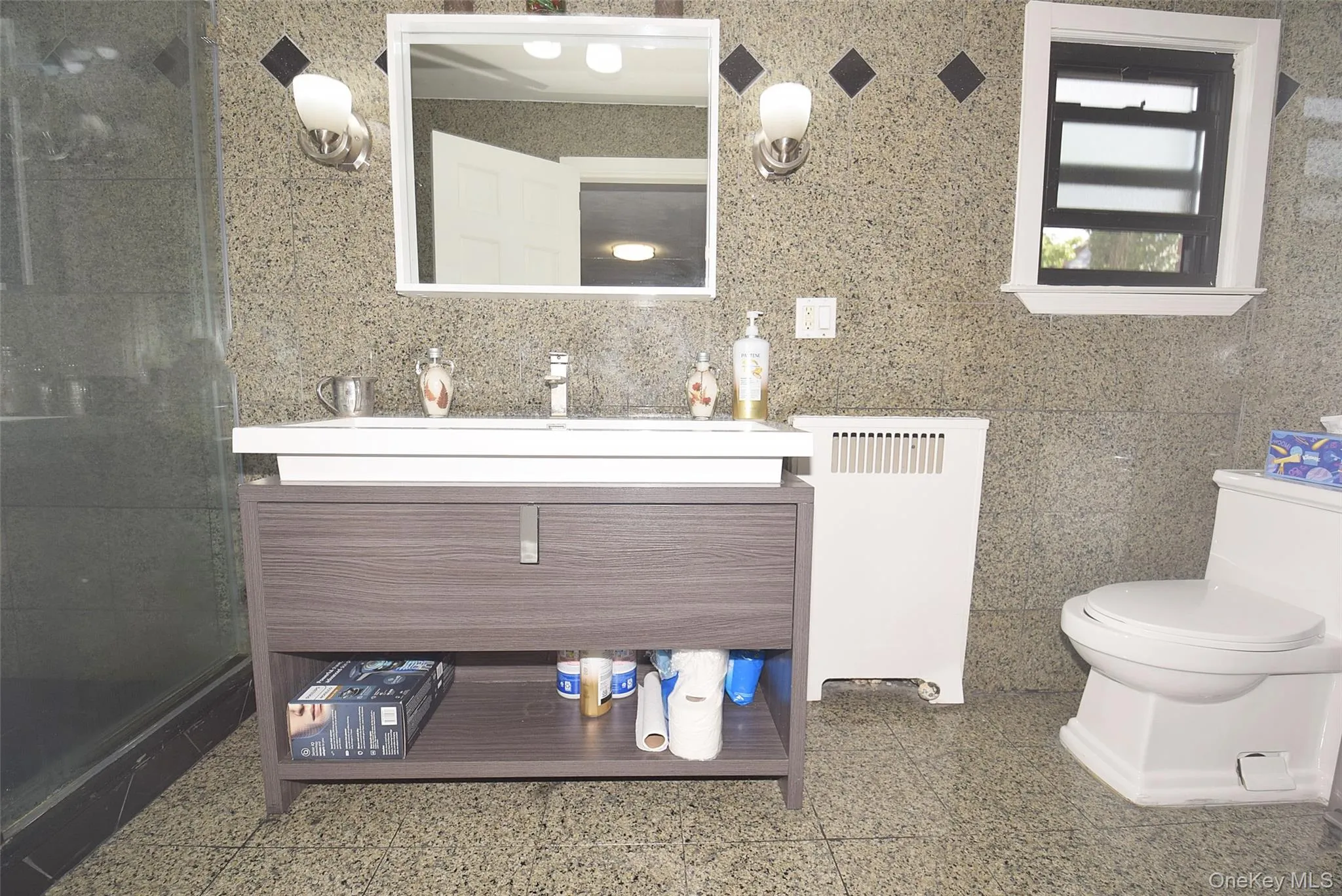 Vanity with contemporary fixtures, wall-mounted mirror, and vanity lighting Vanity with contemporary fixtures, wall-mounted mirror, and vanity lighting