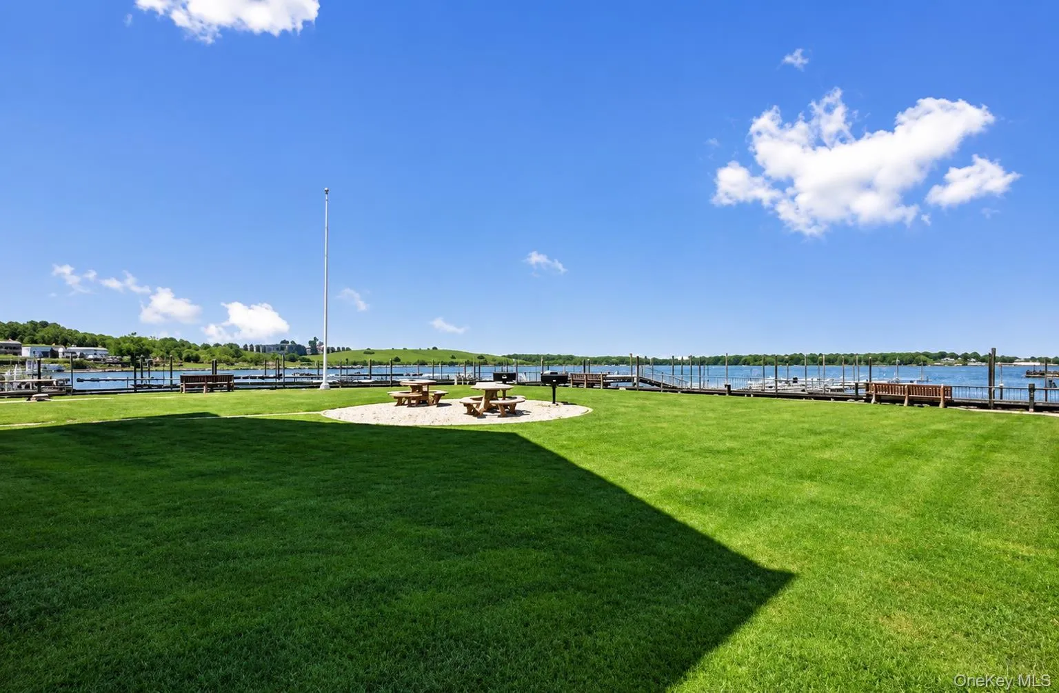 Expansive lawn area with a gravel seating area, a built-in grill, and water access with multiple boat slips Expansive lawn area with a gravel seating area, a built-in grill, and water access with multiple boat slips