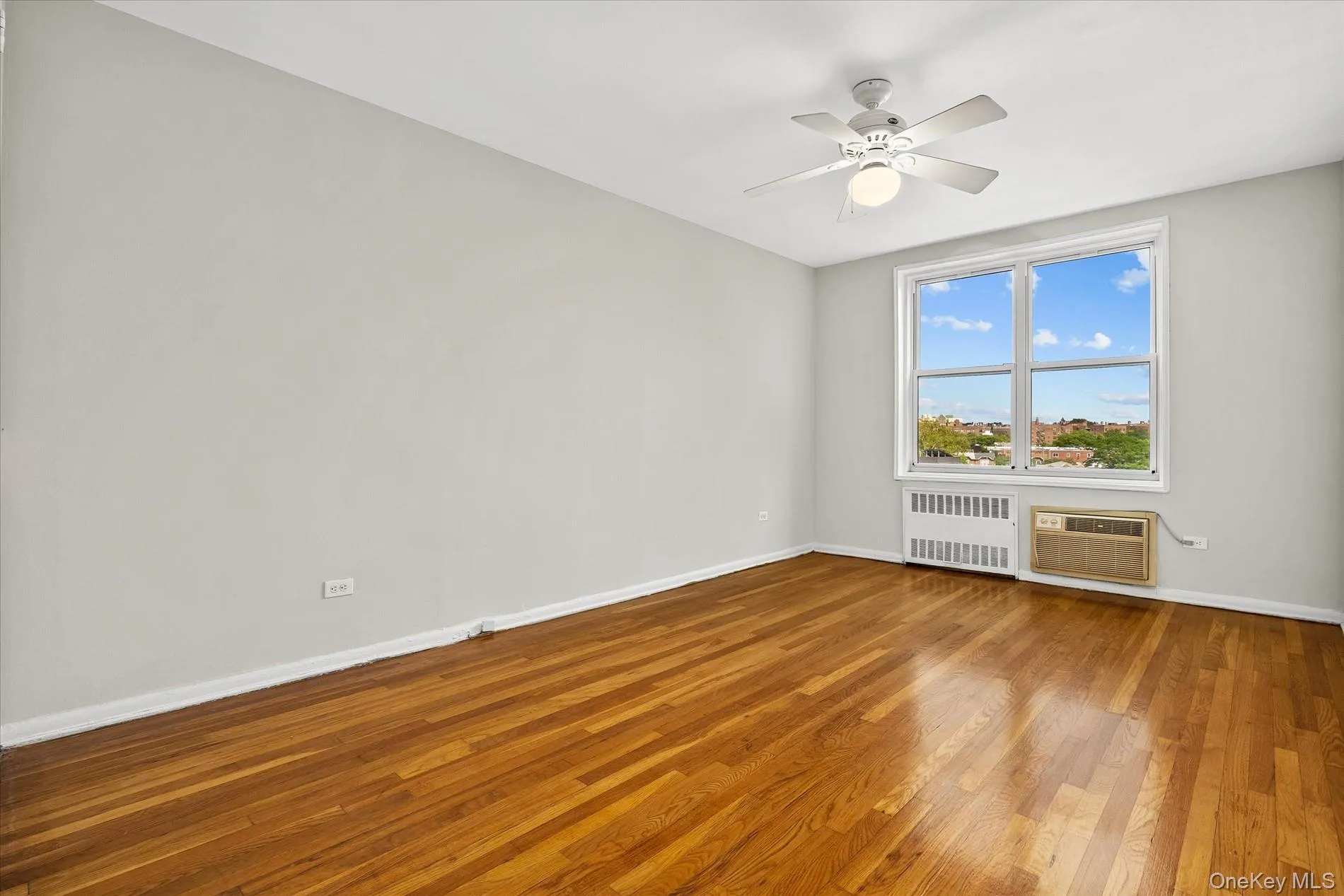 Hardwood flooring, large window, ceiling fan, and painted walls Hardwood flooring, large window, ceiling fan, and painted walls