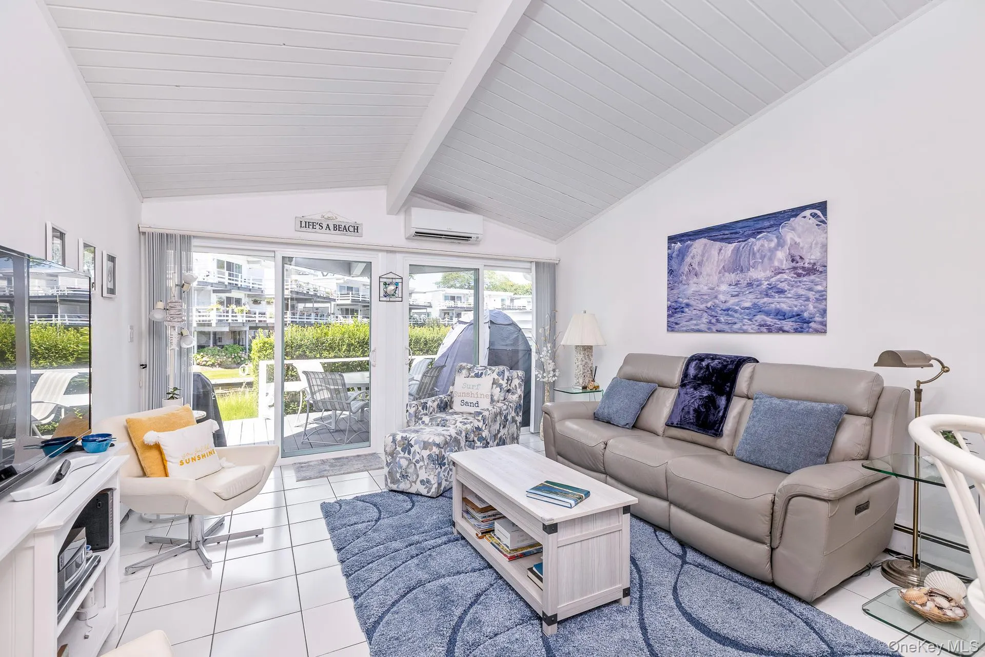 Open Airy Living Room with Vaulted ceiling, Ceramic tile flooring, and sliding glass doors overlooking the water Open Airy Living Room with Vaulted ceiling, Ceramic tile flooring, and sliding glass doors overlooking the water