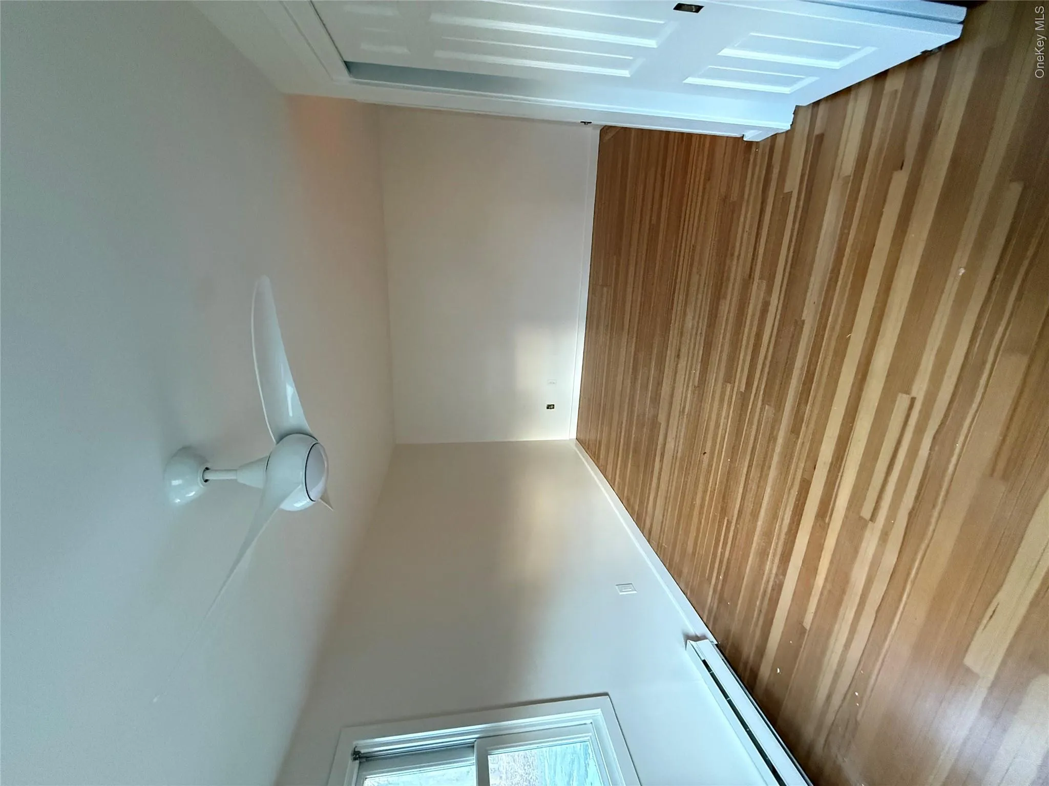 Unfurnished bedroom featuring a baseboard radiator, wood finished floors, and a ceiling fan Unfurnished bedroom featuring a baseboard radiator, wood finished floors, and a ceiling fan