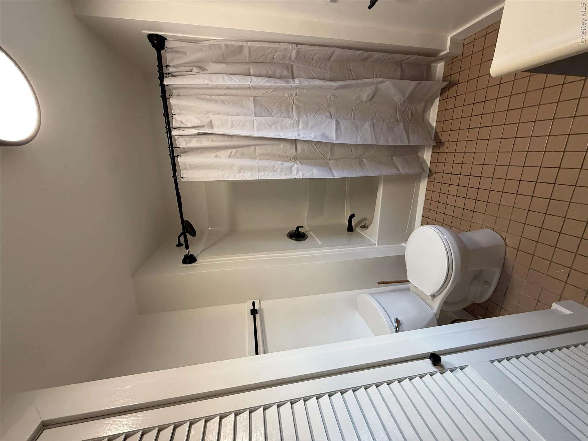 Full bathroom featuring shower / bath combo with shower curtain, tile patterned flooring, and vanity Full bathroom featuring shower / bath combo with shower curtain, tile patterned flooring, and vanity
