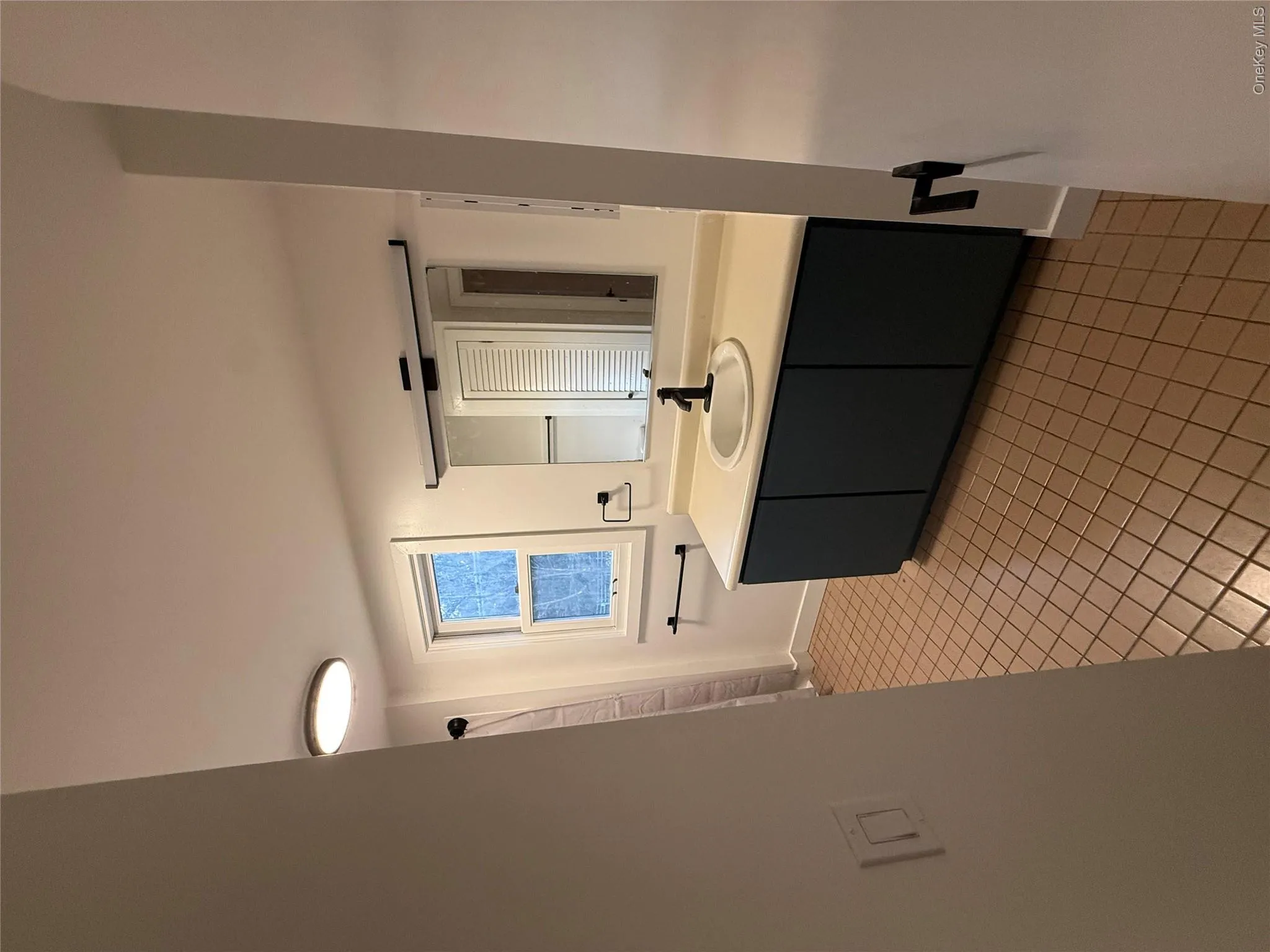 Full bathroom with vanity, a shower with shower curtain, and light tile patterned floors Full bathroom with vanity, a shower with shower curtain, and light tile patterned floors