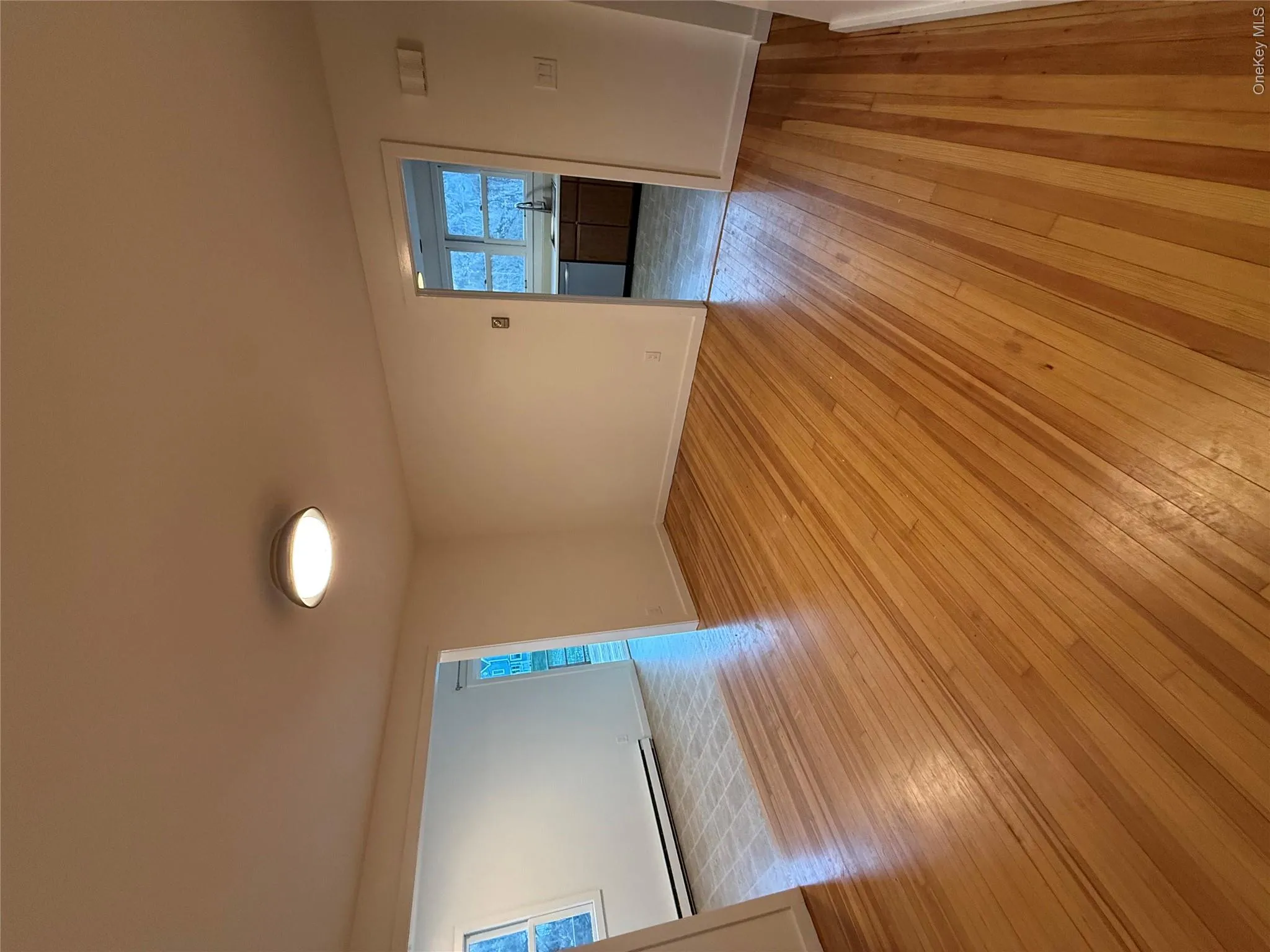 Empty room featuring light wood-style floors and a baseboard heating unit Empty room featuring light wood-style floors and a baseboard heating unit