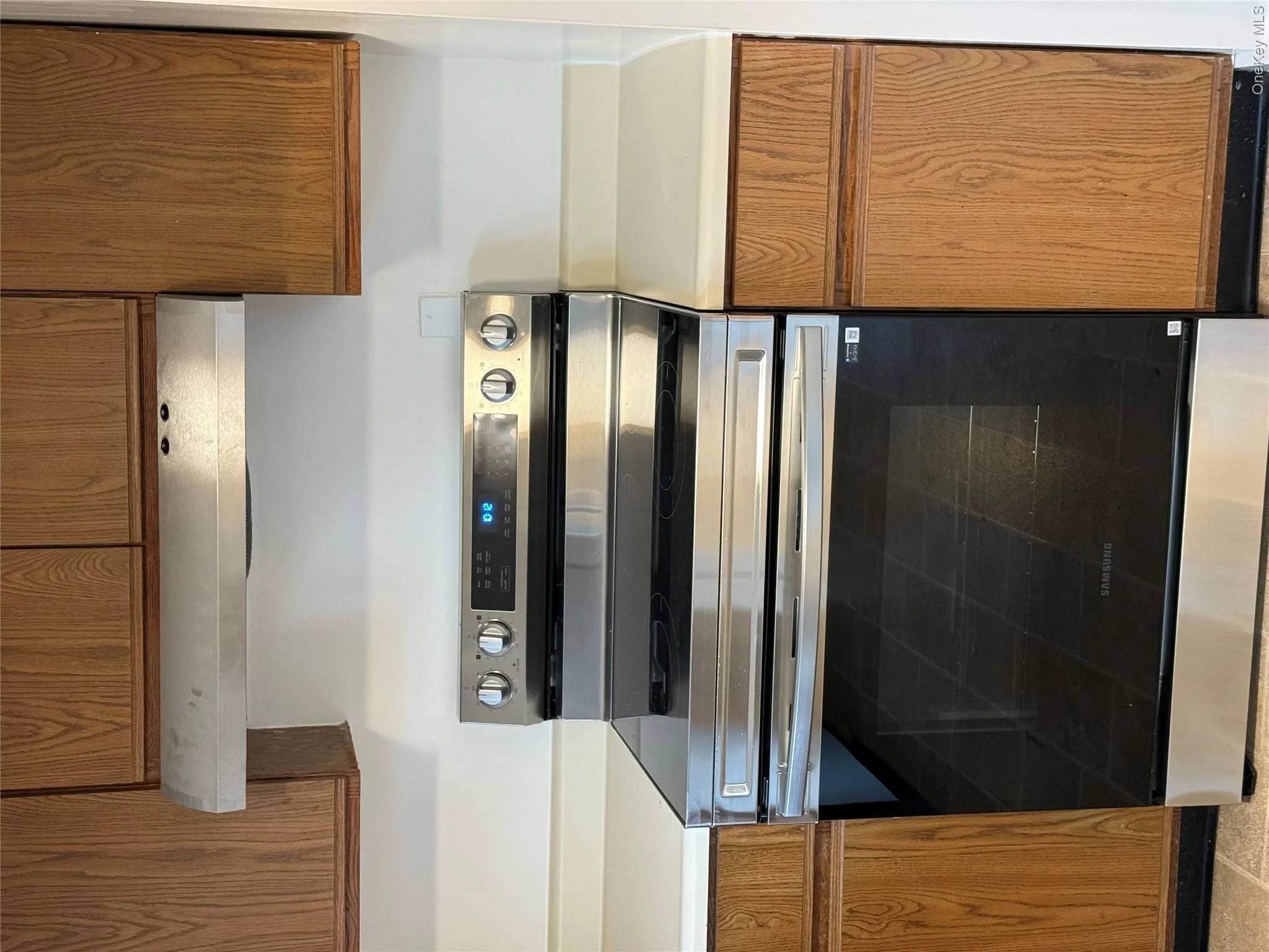 Kitchen featuring stainless steel electric range oven, brown cabinets, light countertops, and extractor fan Kitchen featuring stainless steel electric range oven, brown cabinets, light countertops, and extractor fan
