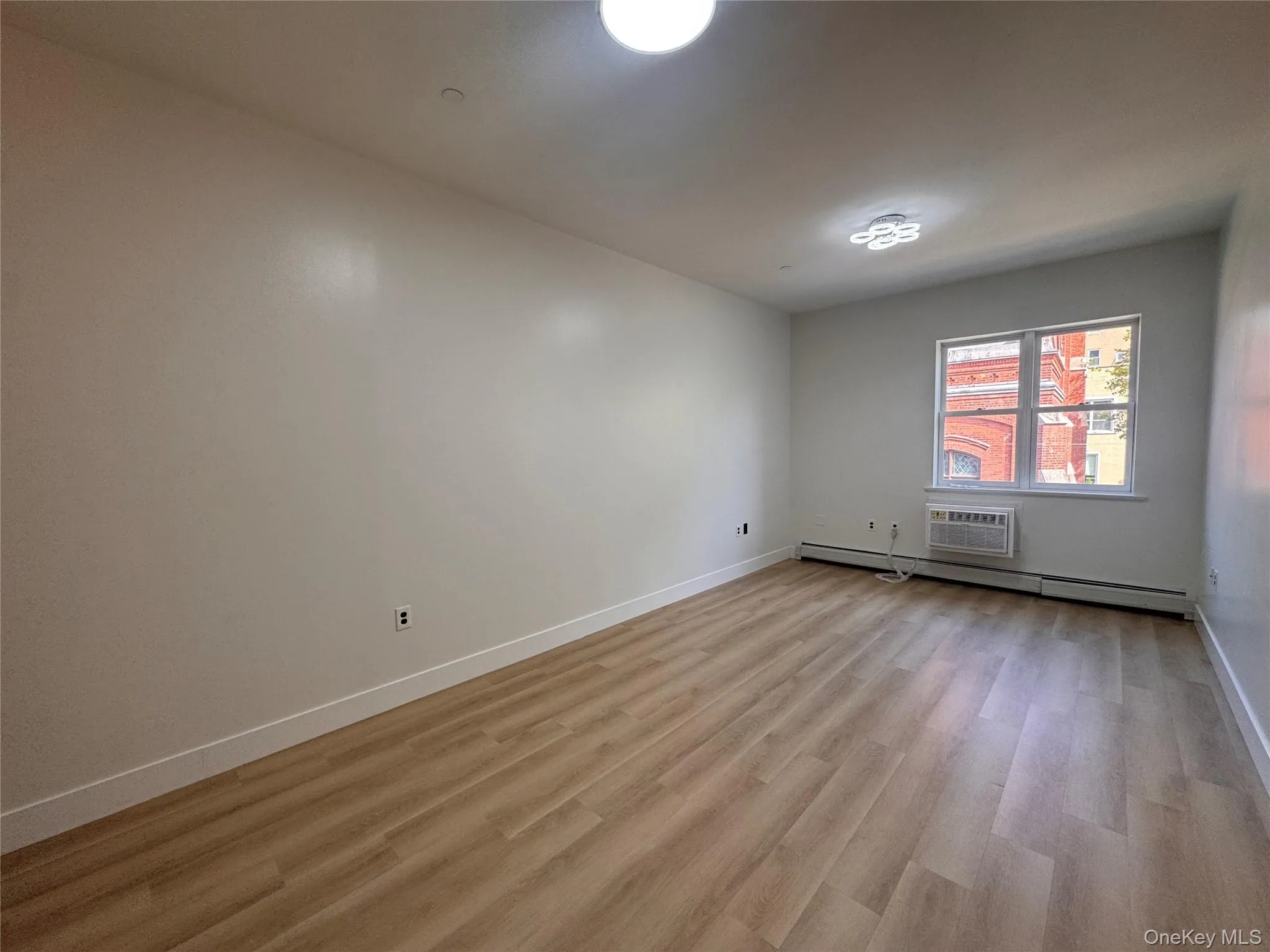 Recessed lighting, wood-finish flooring, window air conditioning unit, and a ceiling-mounted light fixture Recessed lighting, wood-finish flooring, window air conditioning unit, and a ceiling-mounted light fixture