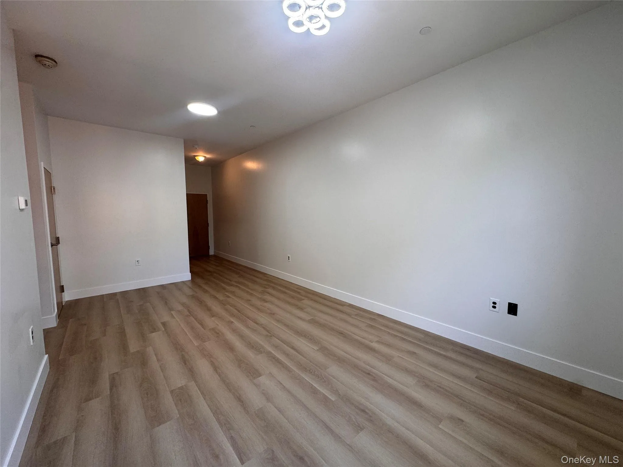 Wood-finish flooring throughout, complemented by a contemporary ceiling light fixture and recessed lighting Wood-finish flooring throughout, complemented by a contemporary ceiling light fixture and recessed lighting