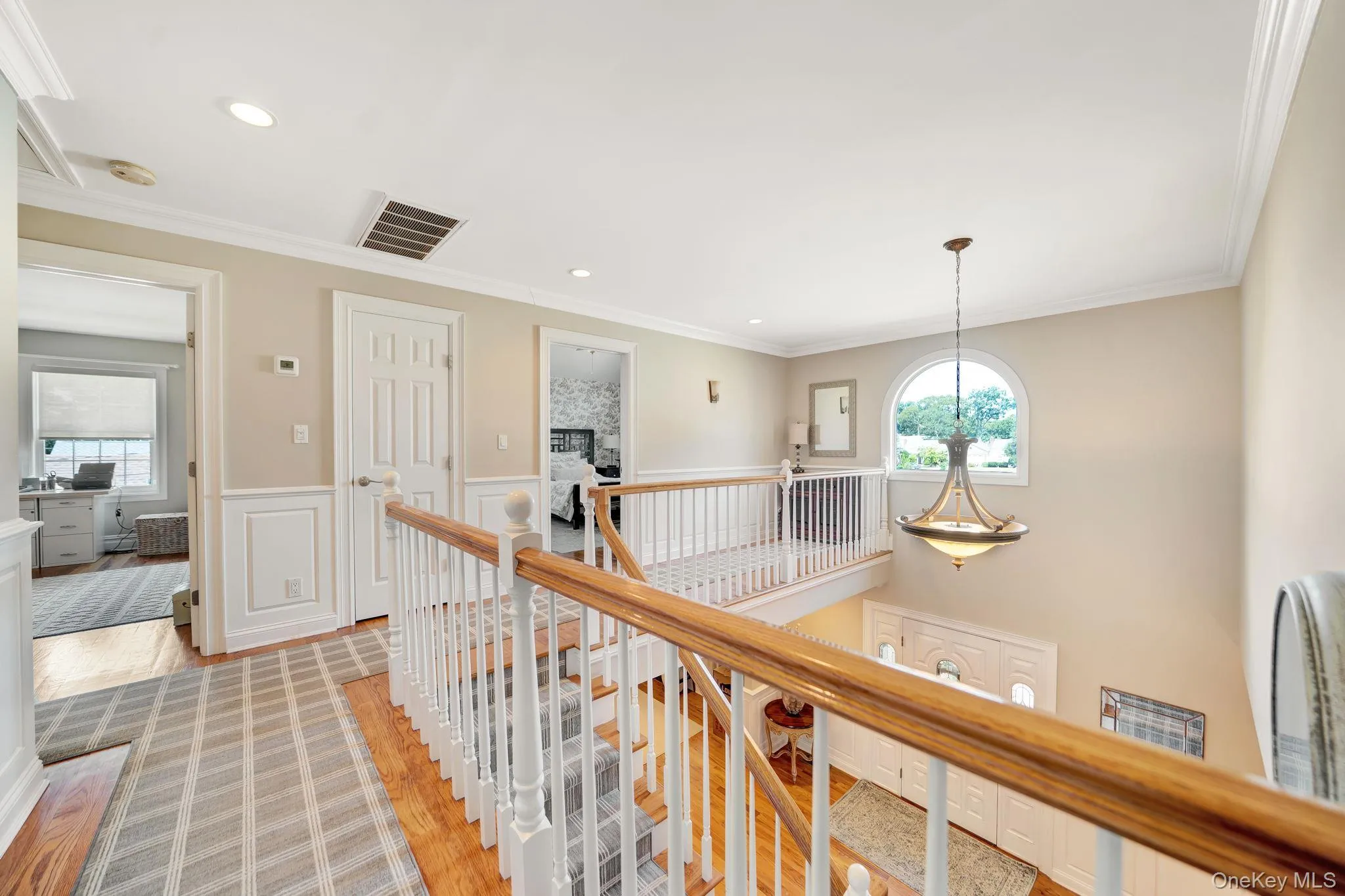 Upper landing with hardwood flooring, custom molding, and recessed lighting Upper landing with hardwood flooring, custom molding, and recessed lighting