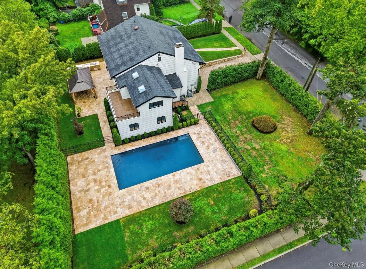 Stunning aerial view showcasing the expansive property, in-ground pool, generous stone patio, lush grounds, and private outdoor entertaining areas. Stunning aerial view showcasing the expansive property, in-ground pool, generous stone patio, lush grounds, and private outdoor entertaining areas.