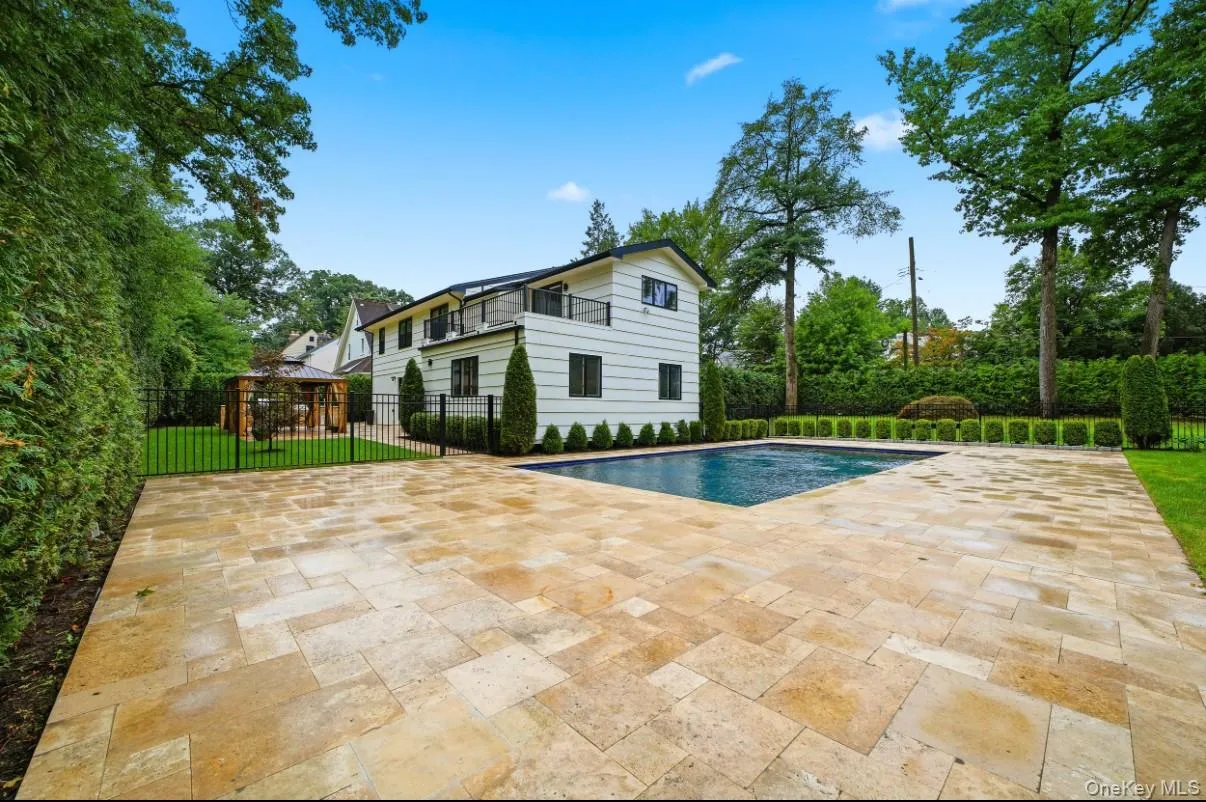 Backyard featuring a sparkling in-ground pool, expansive stone patio, lush landscaping, and plenty of space. Backyard featuring a sparkling in-ground pool, expansive stone patio, lush landscaping, and plenty of space.