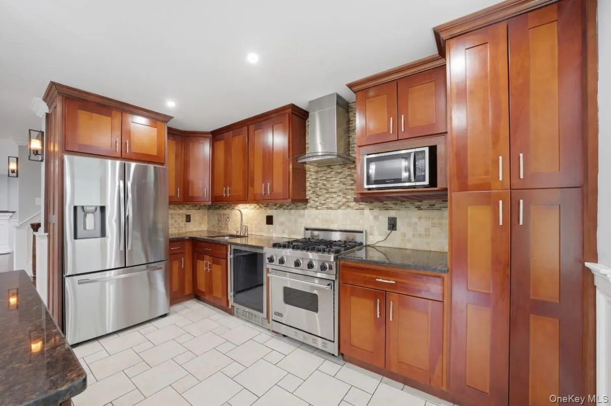 Inviting kitchen with custom-style wood cabinetry, stainless steel appliances, granite counters and abundant natural light Inviting kitchen with custom-style wood cabinetry, stainless steel appliances, granite counters and abundant natural light