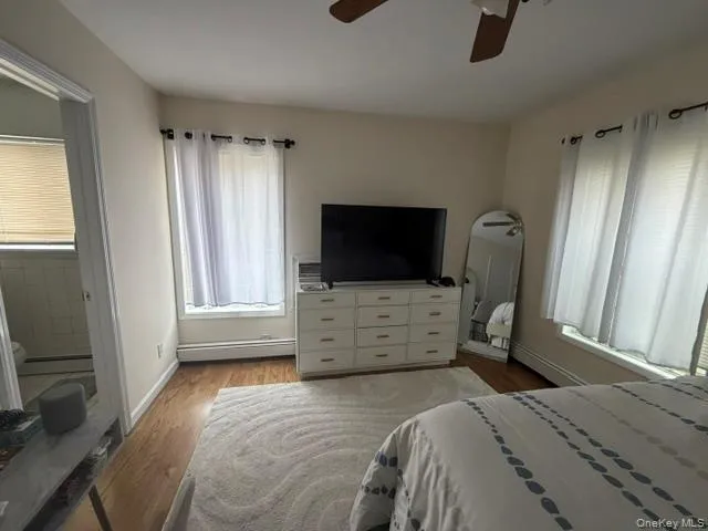 Wood-finish flooring, ceiling fan, and multiple windows Wood-finish flooring, ceiling fan, and multiple windows