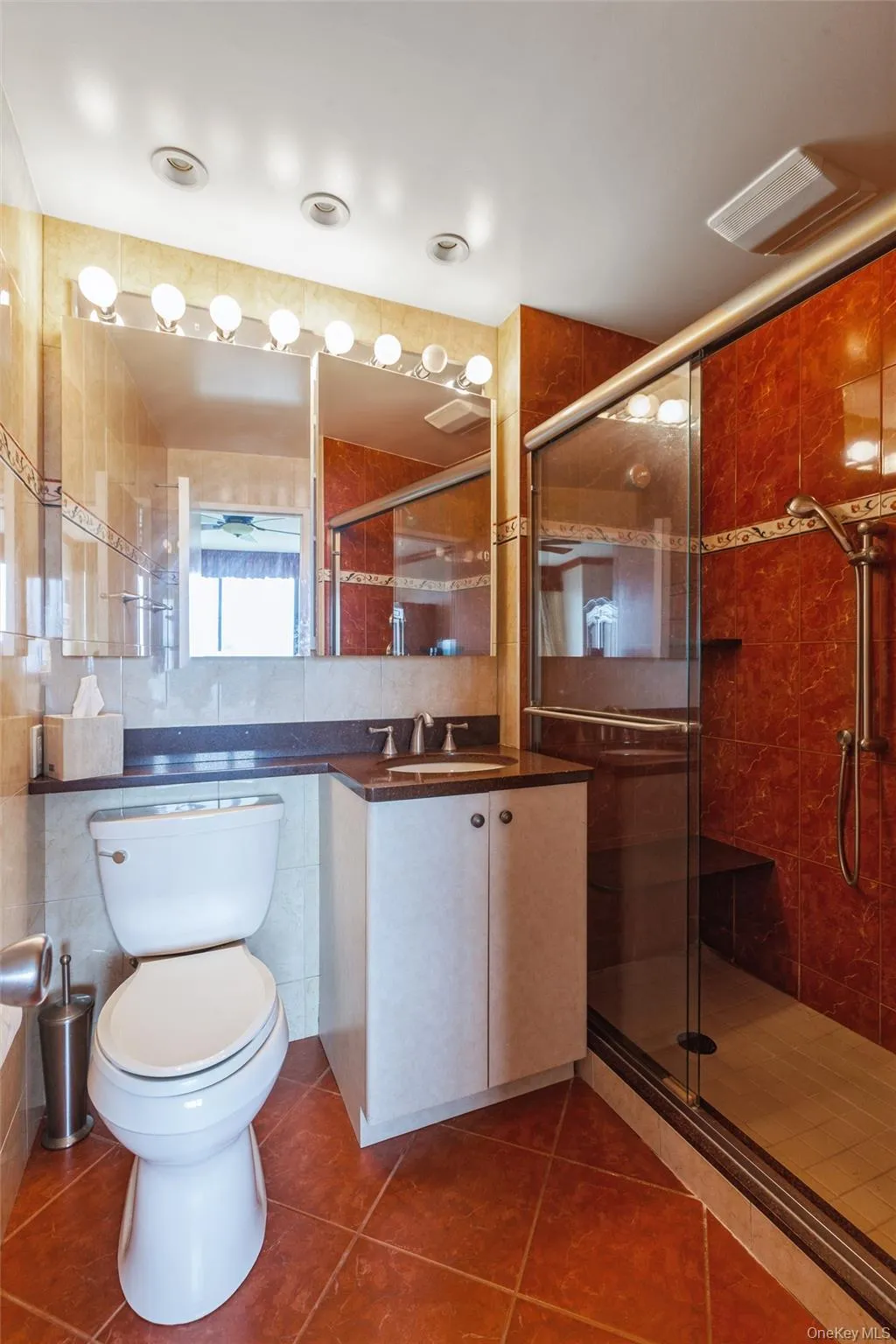 Primary Bathroom with Tiled flooring extending throughout, vanity with integrated sink, glass-enclosed shower with tiled walls and built-in bench, recessed lighting, linen closet Primary Bathroom with Tiled flooring extending throughout, vanity with integrated sink, glass-enclosed shower with tiled walls and built-in bench, recessed lighting, linen closet