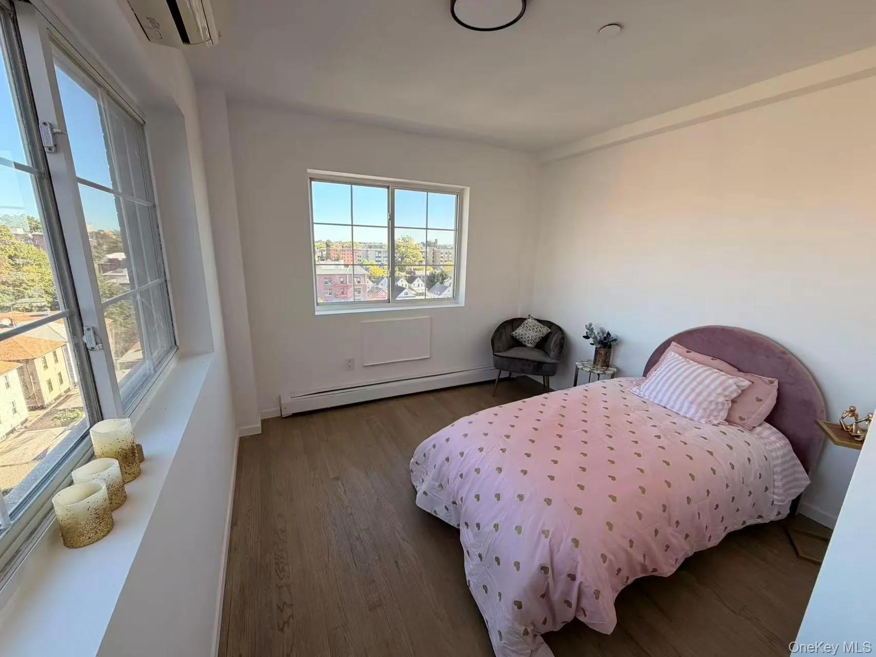 Bedroom with wood finished floors and a baseboard radiator Bedroom with wood finished floors and a baseboard radiator