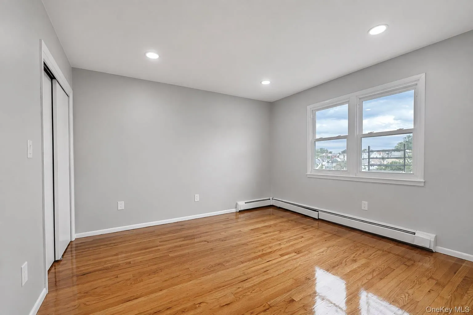 Hardwood flooring, recessed ceiling lighting, light gray wall paint, and white trim window Hardwood flooring, recessed ceiling lighting, light gray wall paint, and white trim window