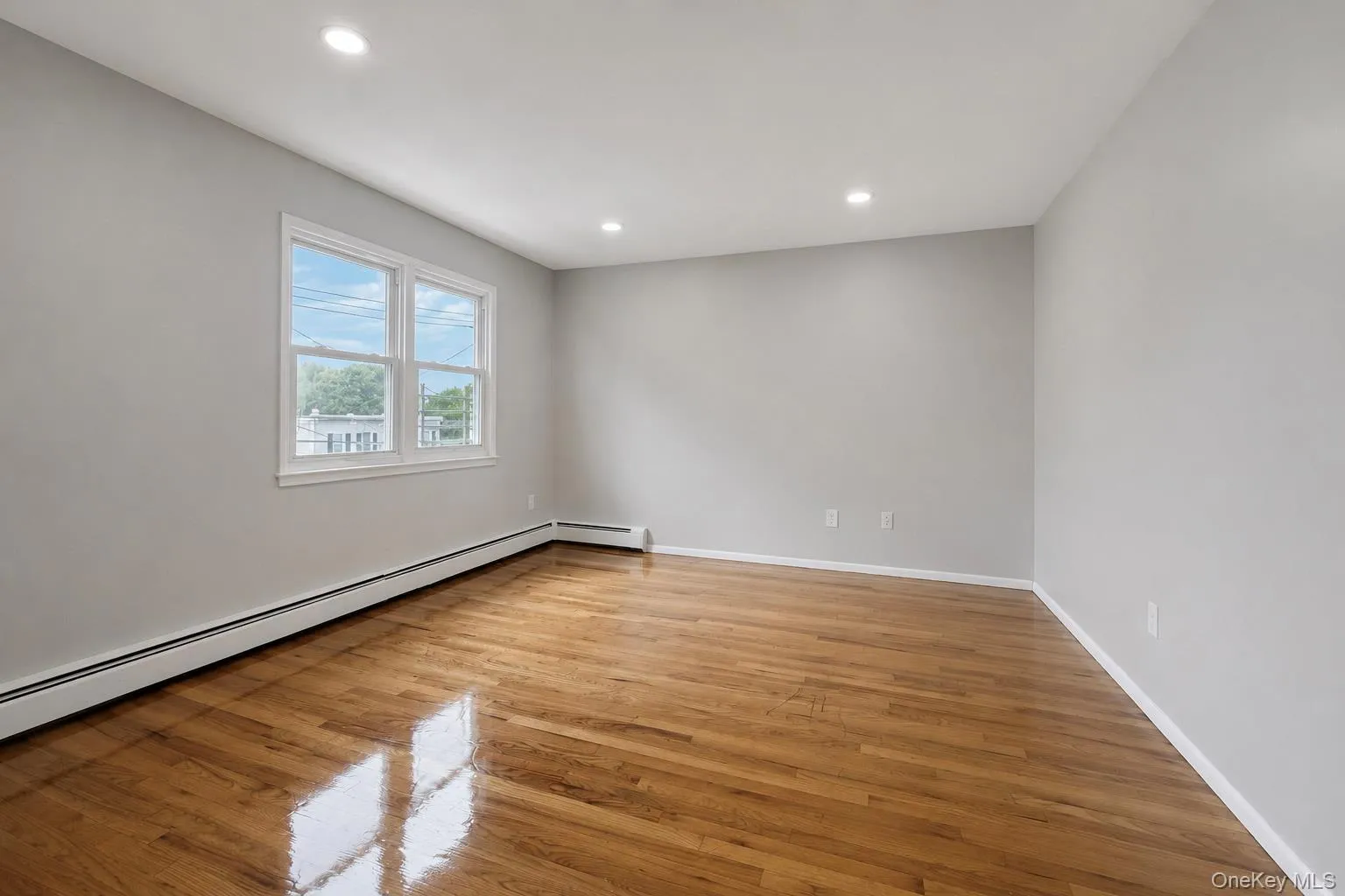 Hardwood flooring, recessed ceiling lighting, light gray wall paint, and white trim window Hardwood flooring, recessed ceiling lighting, light gray wall paint, and white trim window