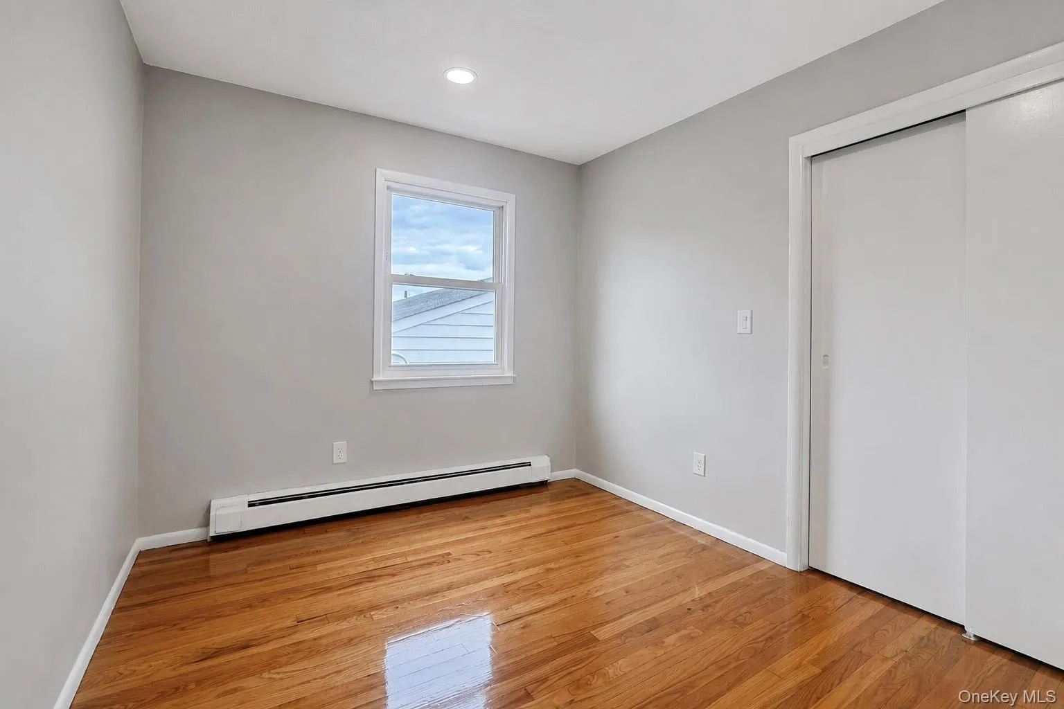 Hardwood flooring, recessed ceiling lighting, light gray wall paint, and white trim window Hardwood flooring, recessed ceiling lighting, light gray wall paint, and white trim window