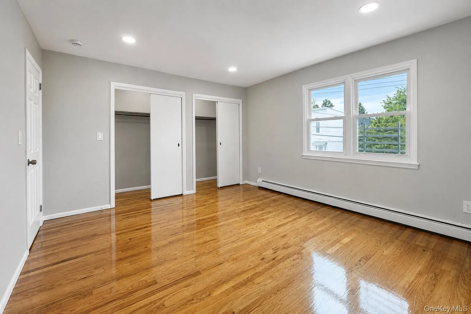 Hardwood flooring, recessed ceiling lighting, light gray wall paint, and white trim window Hardwood flooring, recessed ceiling lighting, light gray wall paint, and white trim window