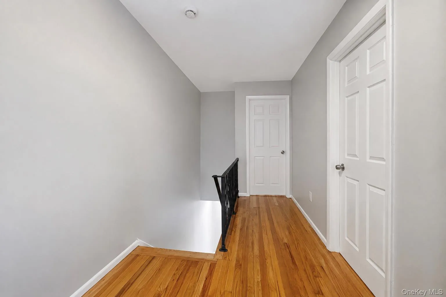 Wood-finish flooring with light gray wall paint and white trim Wood-finish flooring with light gray wall paint and white trim