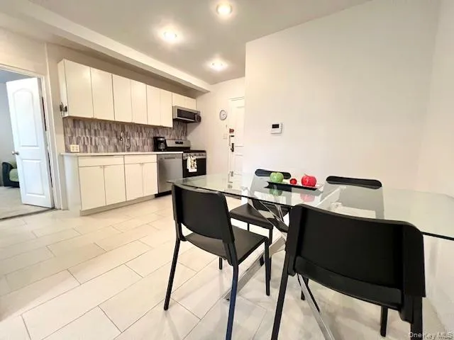Kitchen featuring appliances with stainless steel finishes, tasteful backsplash, white cabinetry, light countertops, and recessed lighting Kitchen featuring appliances with stainless steel finishes, tasteful backsplash, white cabinetry, light countertops, and recessed lighting