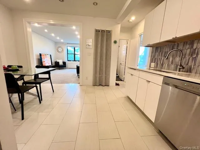Kitchen featuring dishwasher, white cabinets, recessed lighting, light countertops, and tasteful backsplash Kitchen featuring dishwasher, white cabinets, recessed lighting, light countertops, and tasteful backsplash