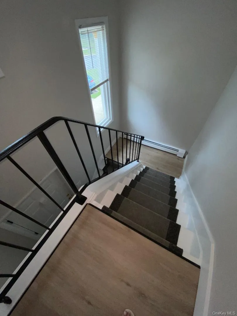 Staircase featuring a patterned carpet runner and white risers Staircase featuring a patterned carpet runner and white risers