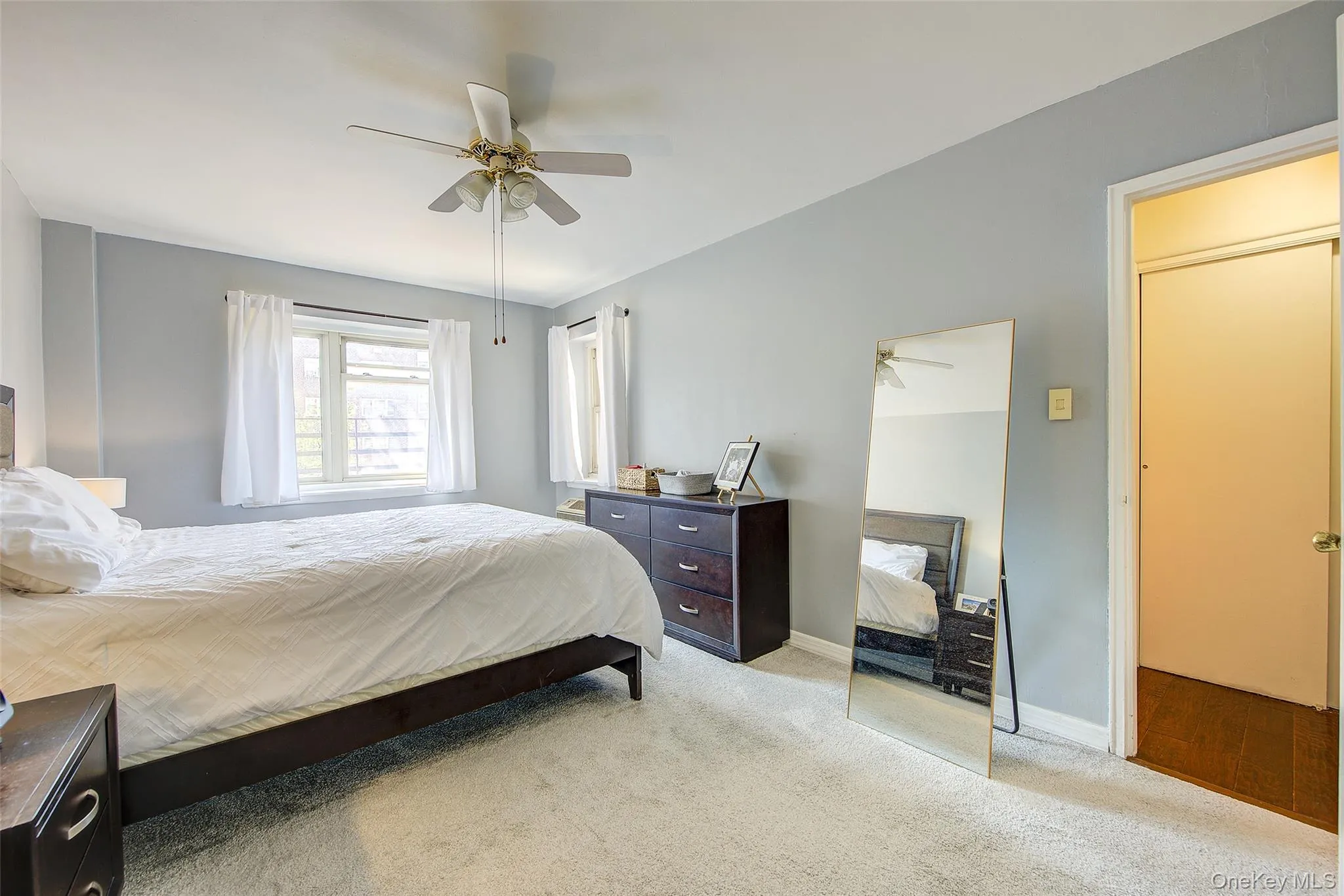 Bedroom featuring light carpet and ceiling fan Bedroom featuring light carpet and ceiling fan
