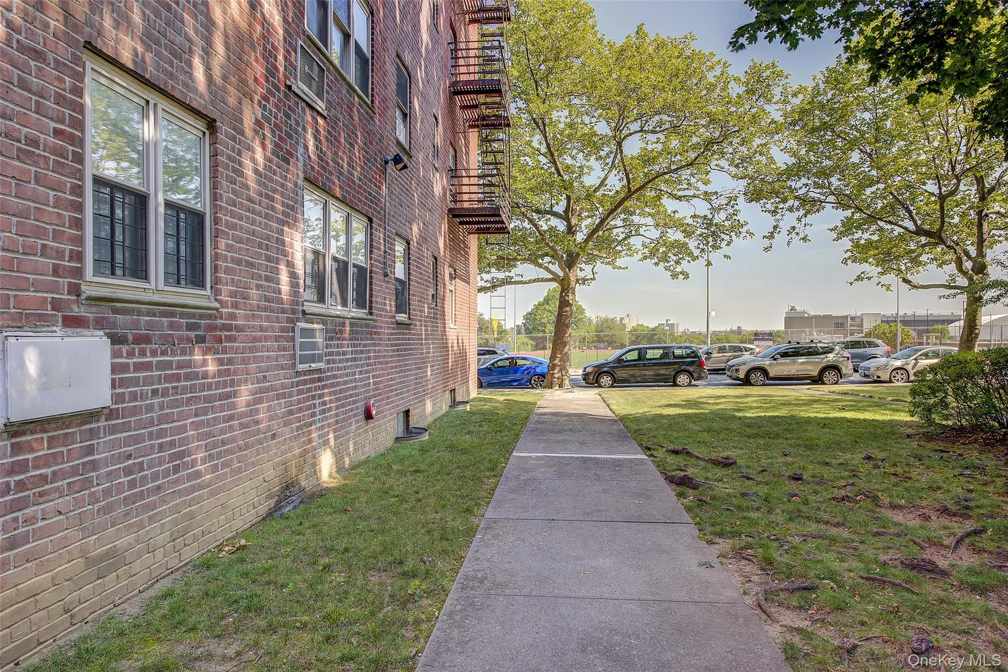 View of home's exterior featuring brick siding, a lawn, and uncovered parking View of home's exterior featuring brick siding, a lawn, and uncovered parking