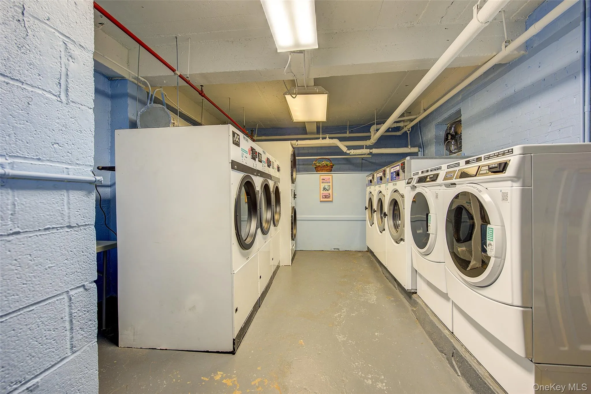 Community laundry room with independent washer and dryer and concrete block wall Community laundry room with independent washer and dryer and concrete block wall