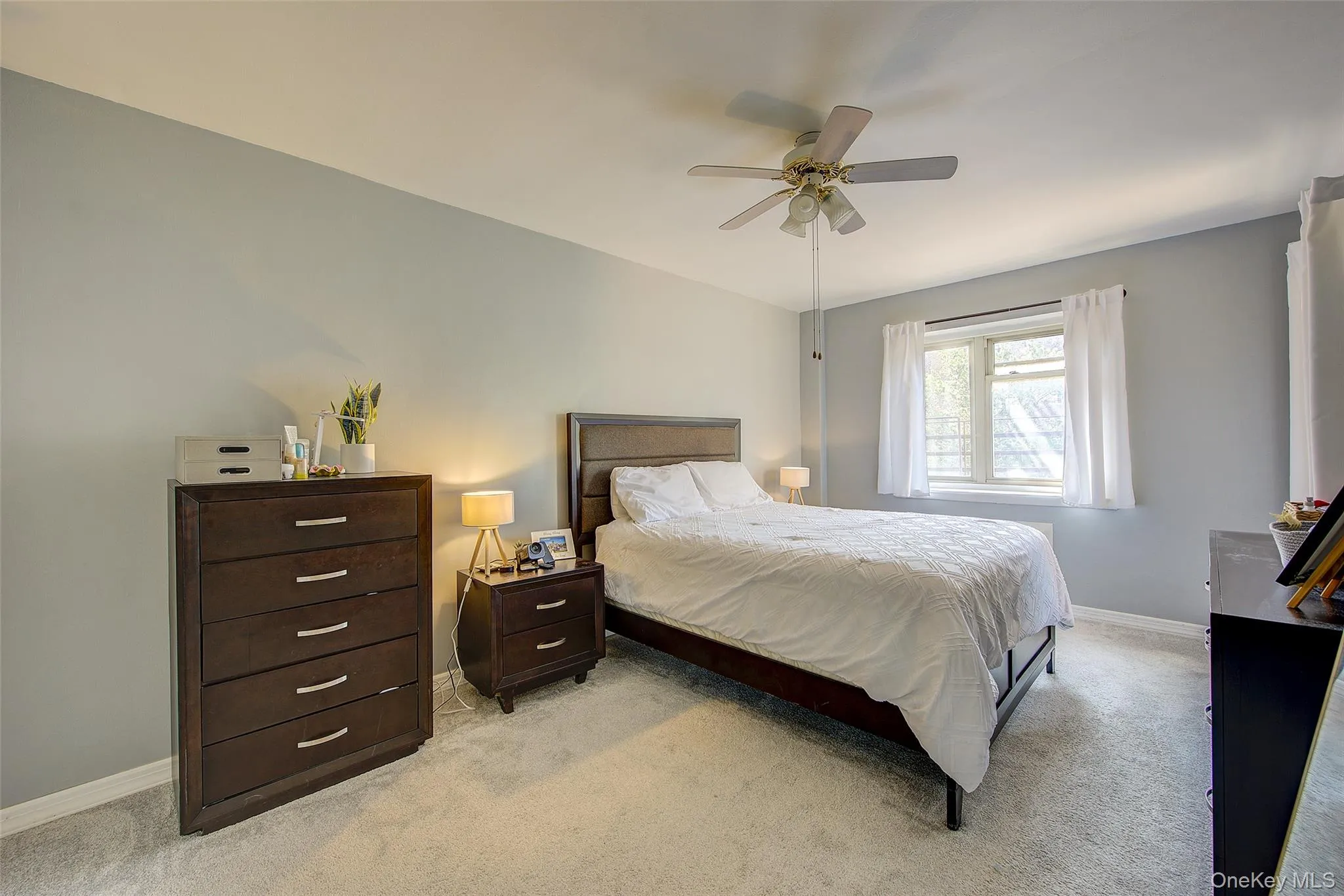 Bedroom with light carpet and a ceiling fan Bedroom with light carpet and a ceiling fan