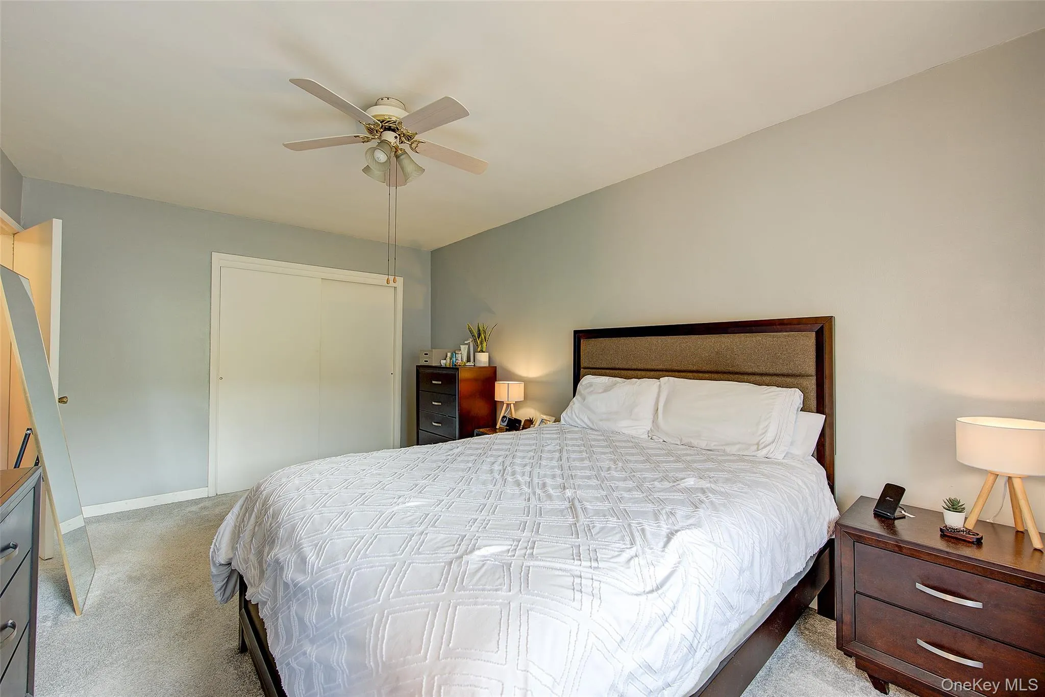 Carpeted bedroom featuring a closet and ceiling fan Carpeted bedroom featuring a closet and ceiling fan