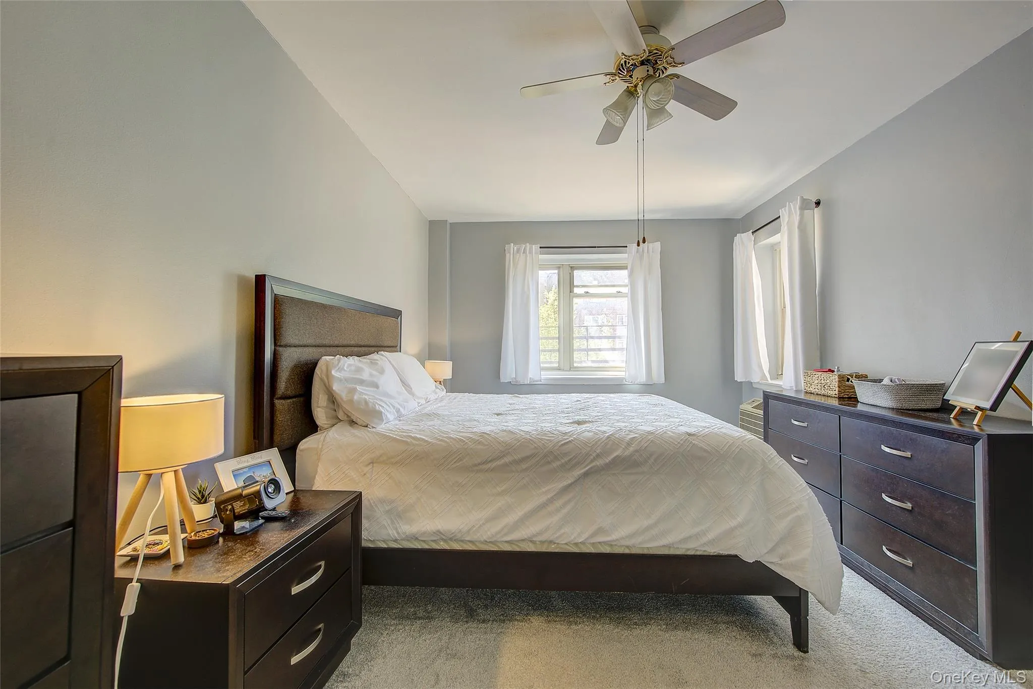 Carpeted bedroom with a ceiling fan Carpeted bedroom with a ceiling fan