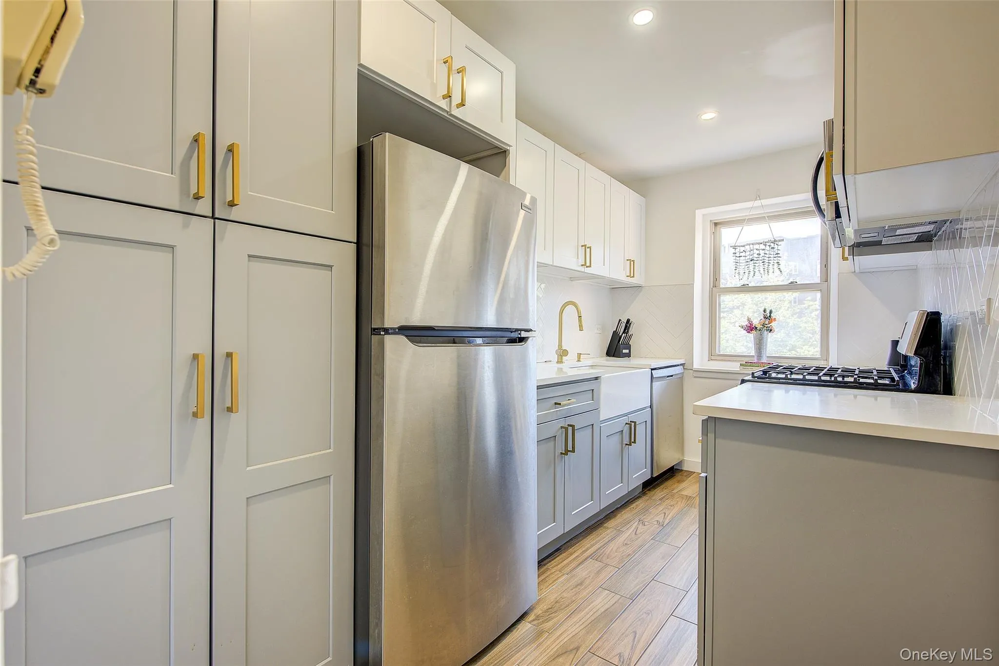 Kitchen featuring appliances with stainless steel finishes, light countertops, recessed lighting, tasteful backsplash, and light wood finished floors Kitchen featuring appliances with stainless steel finishes, light countertops, recessed lighting, tasteful backsplash, and light wood finished floors