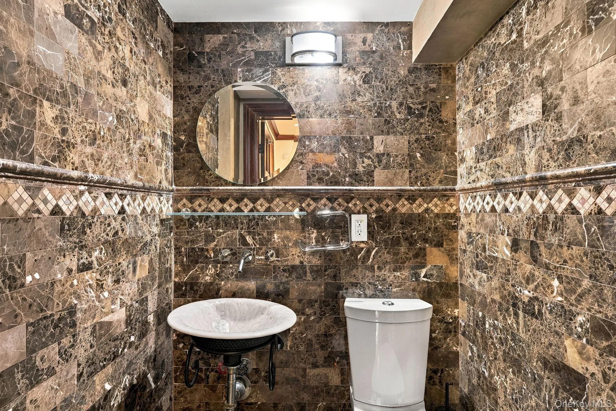 A marble-clad powder room adds a refined touch. A marble-clad powder room adds a refined touch.
