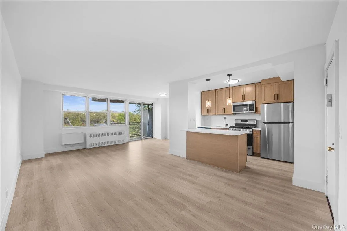Open-concept living space with light vinyl flooring, and white walls Open-concept living space with light vinyl flooring, and white walls