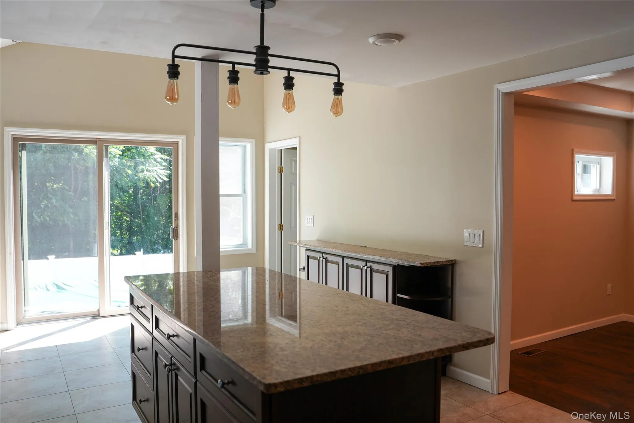 Kitchen island with dark cabinetry and a stone countertop Kitchen island with dark cabinetry and a stone countertop