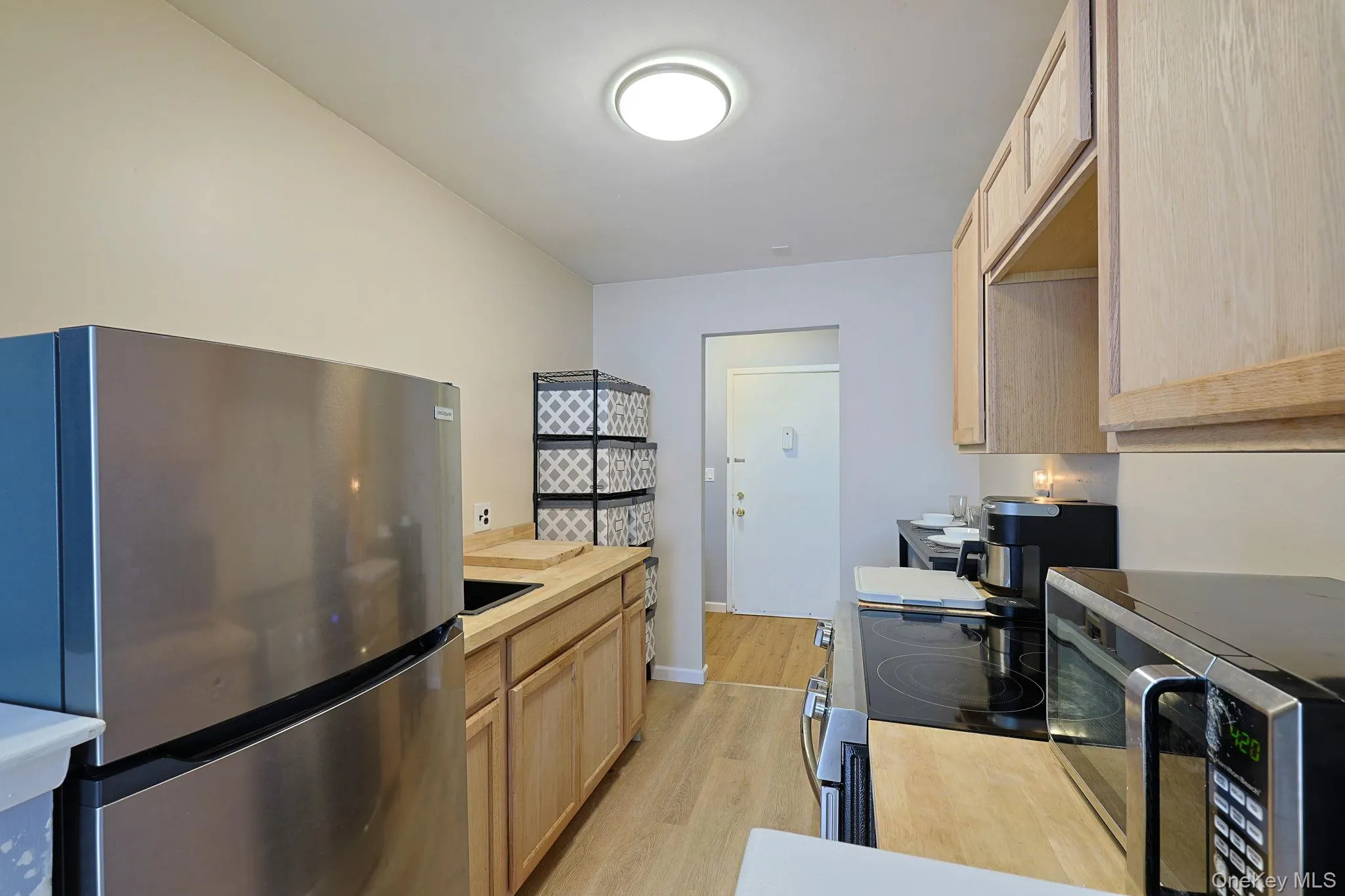 Kitchen featuring wood-finish cabinetry, stainless steel appliances, a black sink with a matte black faucet, and wood-finish countertops Kitchen featuring wood-finish cabinetry, stainless steel appliances, a black sink with a matte black faucet, and wood-finish countertops