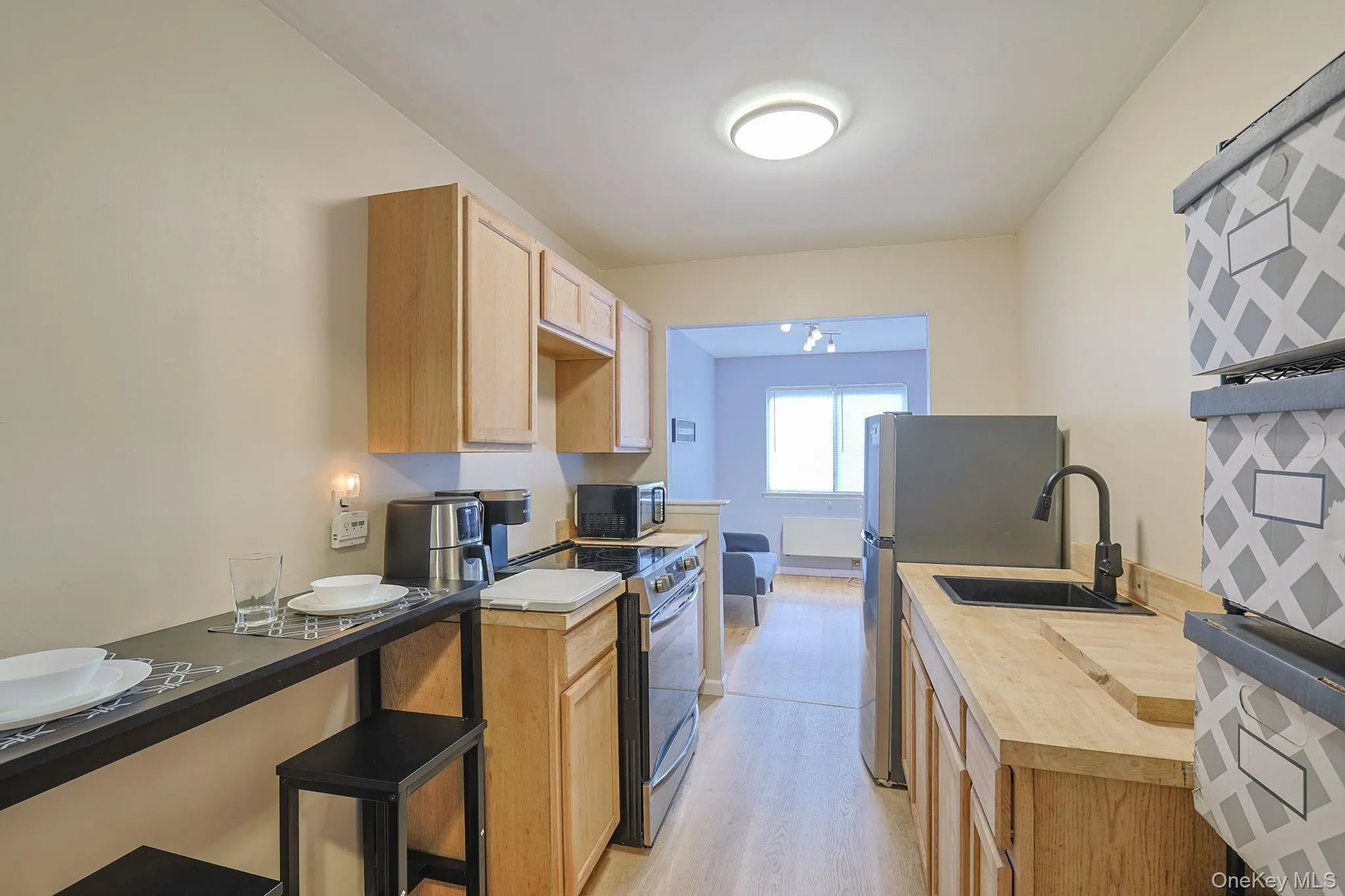 Kitchen featuring wood-finish cabinetry, stainless steel appliances, a black sink with a matte black faucet, and wood-finish countertops Kitchen featuring wood-finish cabinetry, stainless steel appliances, a black sink with a matte black faucet, and wood-finish countertops
