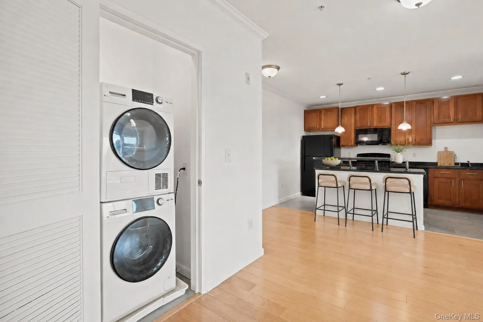 Hardwood-style flooring throughout, kitchen featuring wood cabinetry, dark countertops, and WD appliances Hardwood-style flooring throughout, kitchen featuring wood cabinetry, dark countertops, and WD appliances