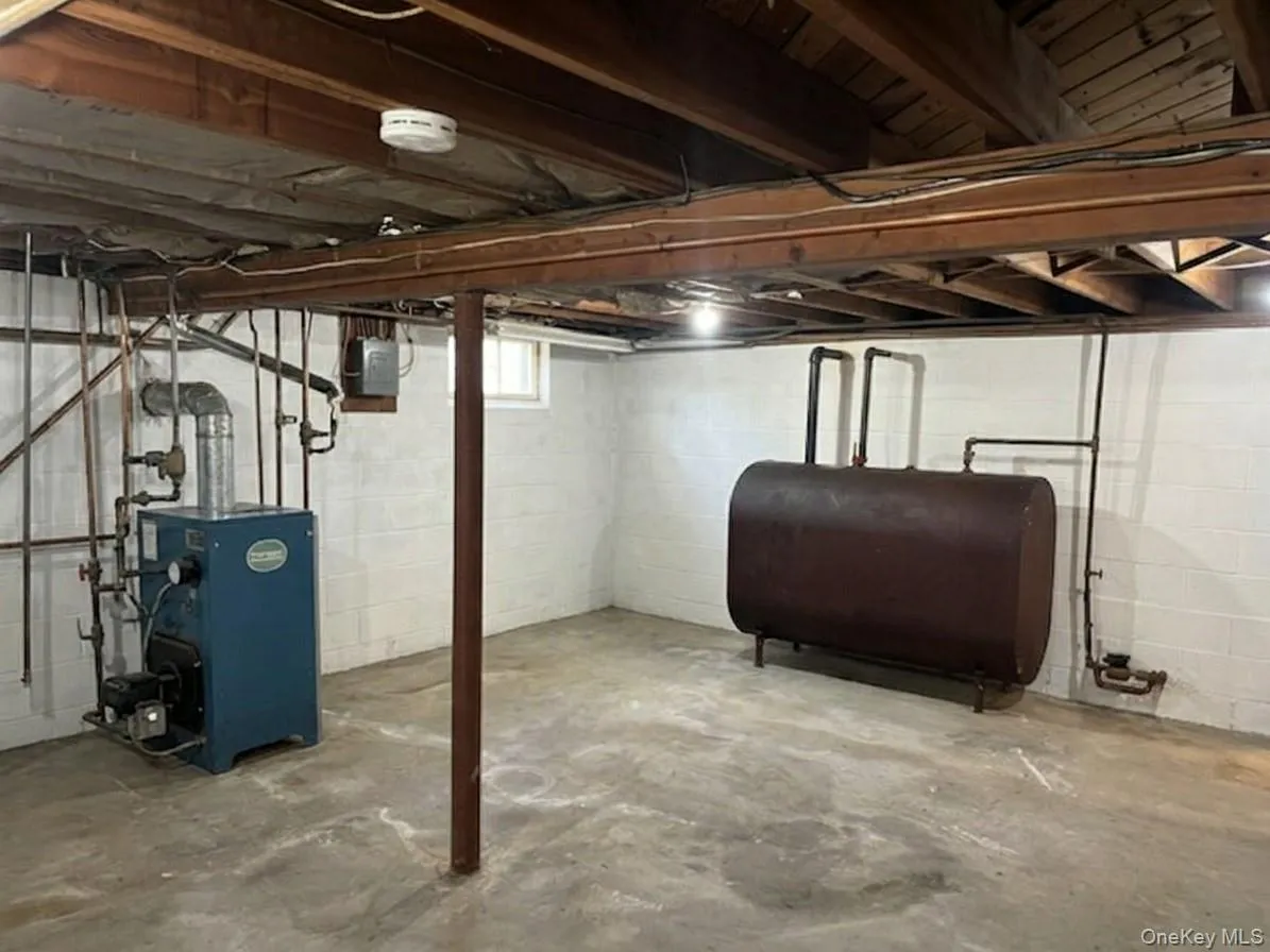 Unfinished portion of basement with Oil Burner and interior oil tank Unfinished portion of basement with Oil Burner and interior oil tank
