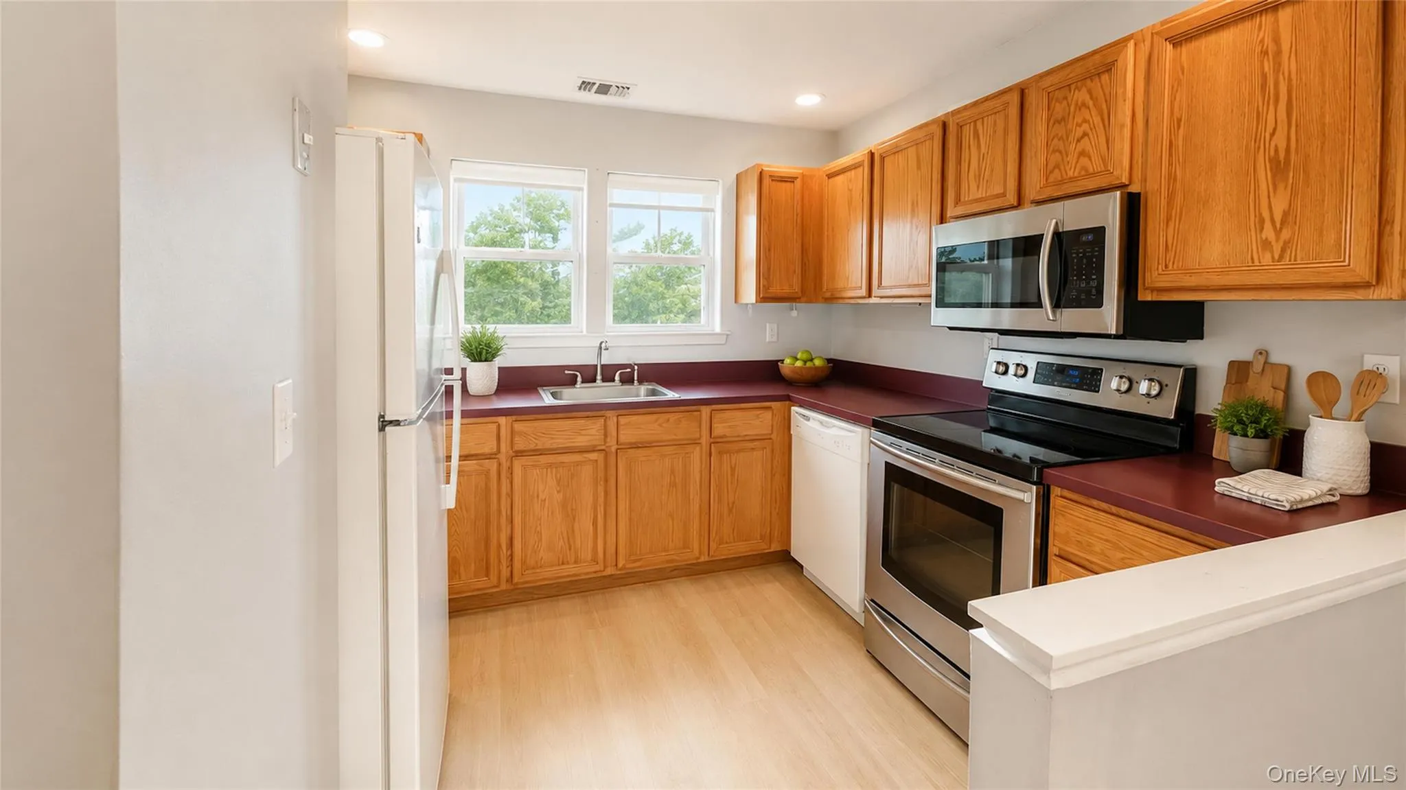 Bright, functional kitchen featuring abundant wood cabinetry, generous counter space, stainless-steel cooking appliances, and excellent natural light. Bright, functional kitchen featuring abundant wood cabinetry, generous counter space, stainless-steel cooking appliances, and excellent natural light.