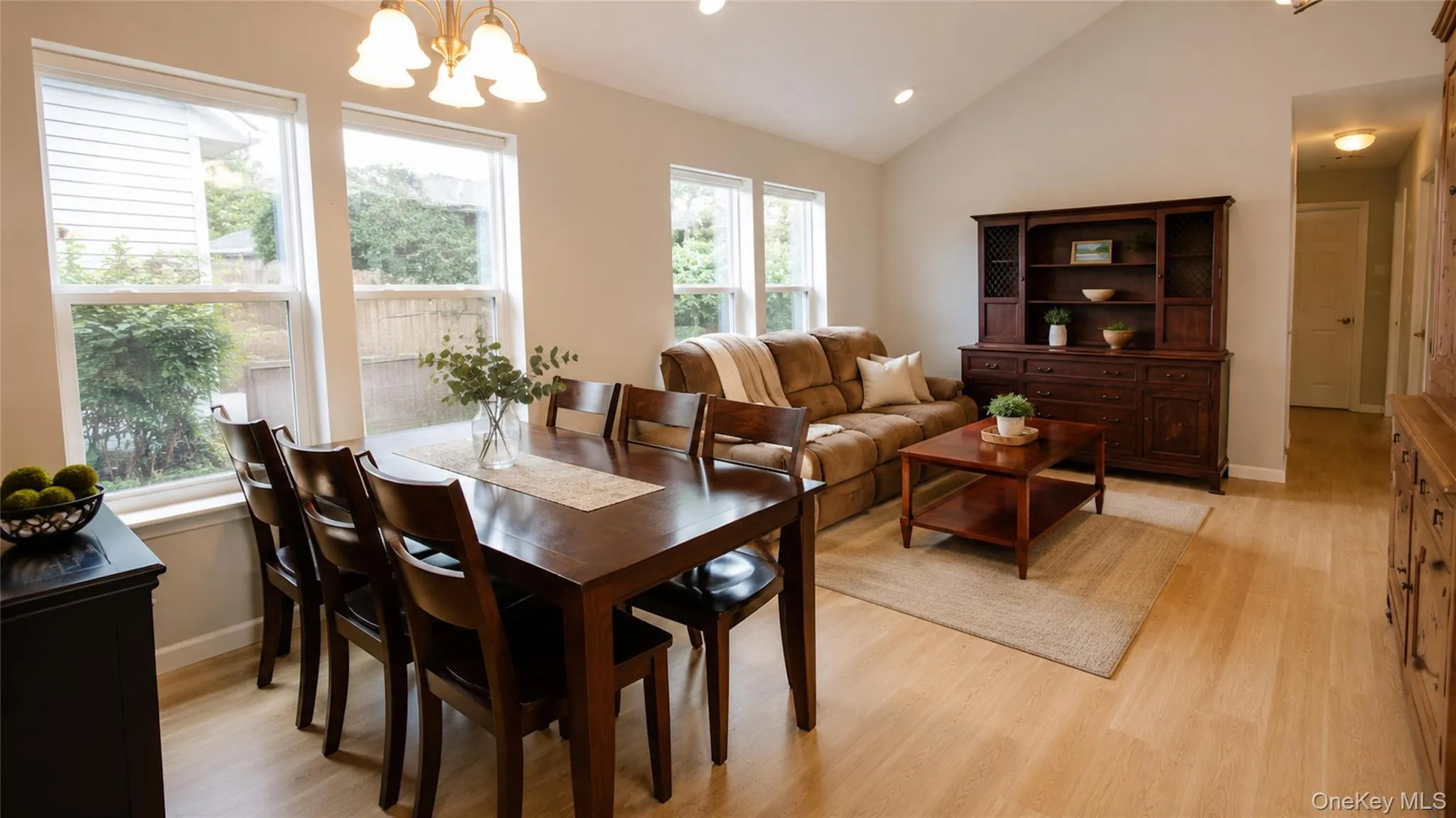 Spacious open-concept living and dining area with vaulted ceilings, abundant windows, and a warm, inviting flow for entertaining. Spacious open-concept living and dining area with vaulted ceilings, abundant windows, and a warm, inviting flow for entertaining.