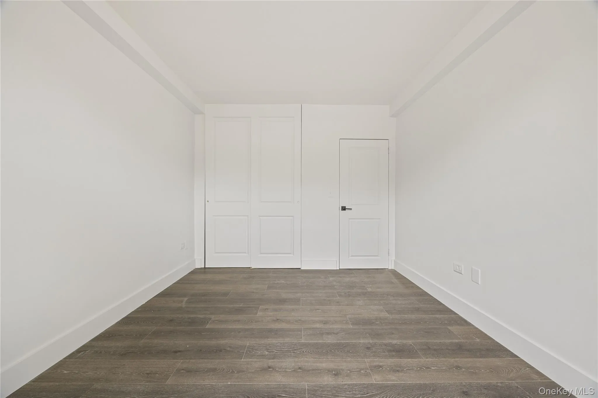 Vinyl flooring throughout, bright white walls, and a window with a built-in air conditioning unit Vinyl flooring throughout, bright white walls, and a window with a built-in air conditioning unit