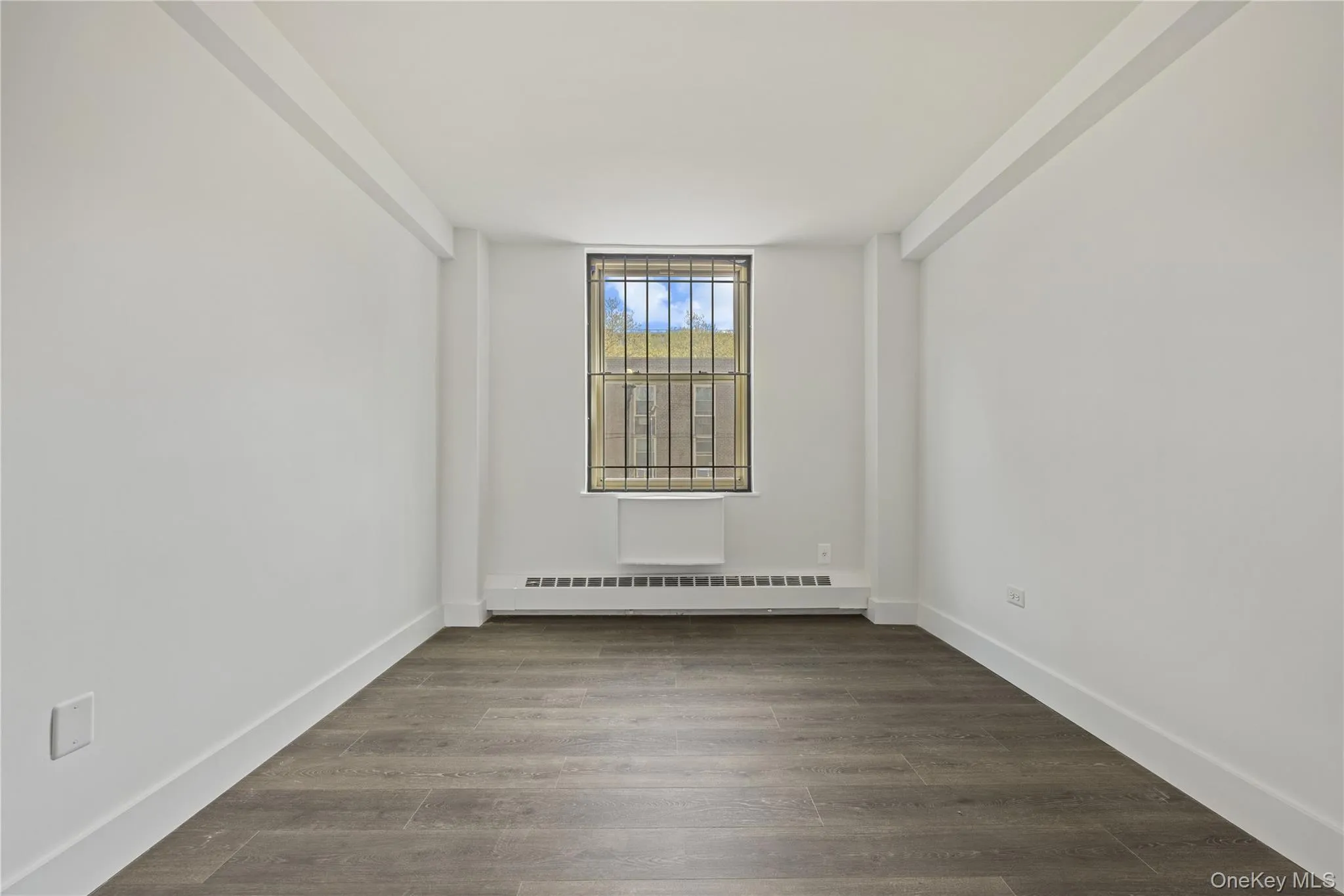 Vinyl flooring throughout, bright white walls, and a window with a built-in air conditioning unit Vinyl flooring throughout, bright white walls, and a window with a built-in air conditioning unit
