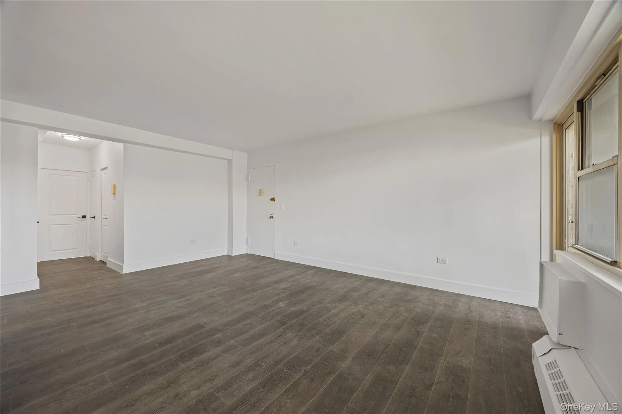 Vinyl flooring throughout, bright white walls, and a window with a built-in air conditioning unit Vinyl flooring throughout, bright white walls, and a window with a built-in air conditioning unit