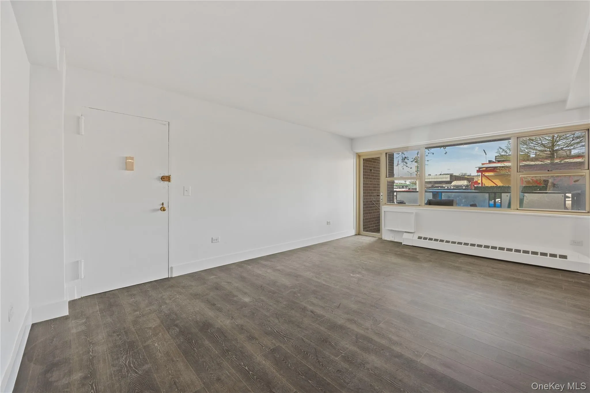 Vinyl flooring throughout, bright white walls, and a window with a built-in air conditioning unit Vinyl flooring throughout, bright white walls, and a window with a built-in air conditioning unit