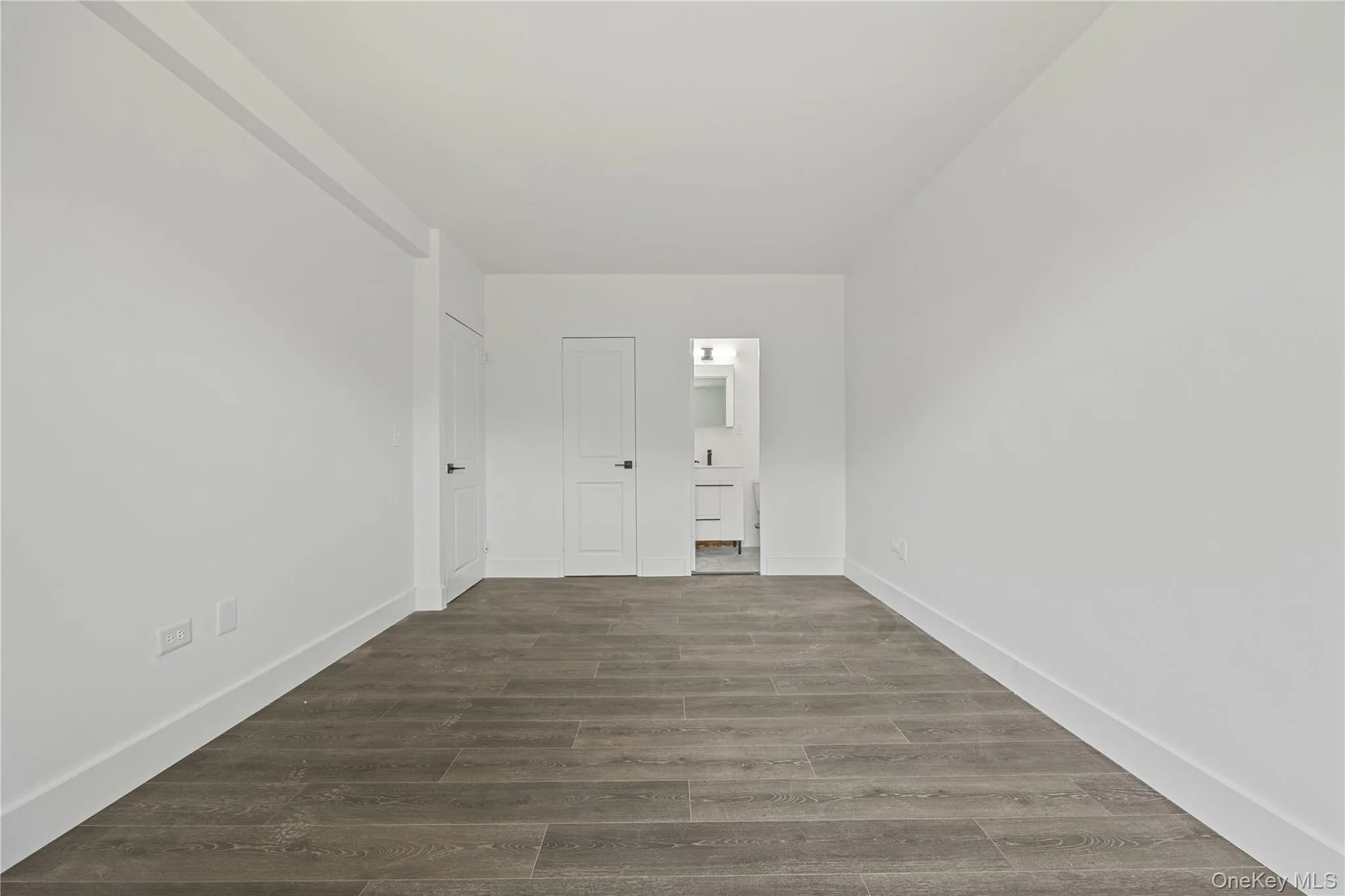 Vinyl flooring throughout, bright white walls, and a window with a built-in air conditioning unit Vinyl flooring throughout, bright white walls, and a window with a built-in air conditioning unit