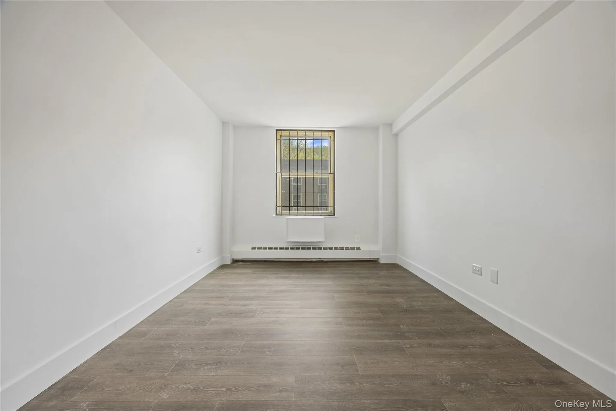 Vinyl flooring throughout, bright white walls, and a window with a built-in air conditioning unit Vinyl flooring throughout, bright white walls, and a window with a built-in air conditioning unit