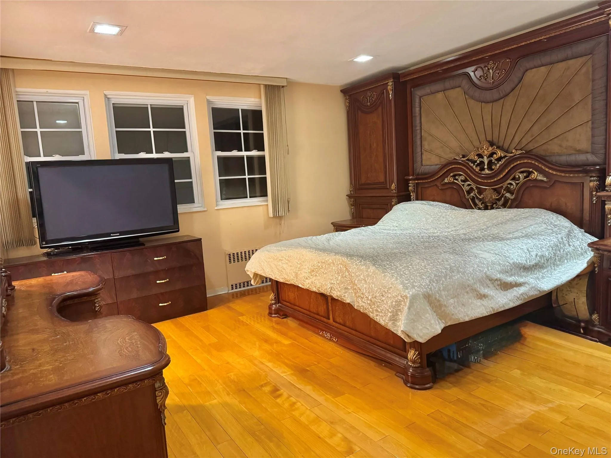Hardwood flooring, recessed ceiling lighting, three windows, and radiator heating Hardwood flooring, recessed ceiling lighting, three windows, and radiator heating